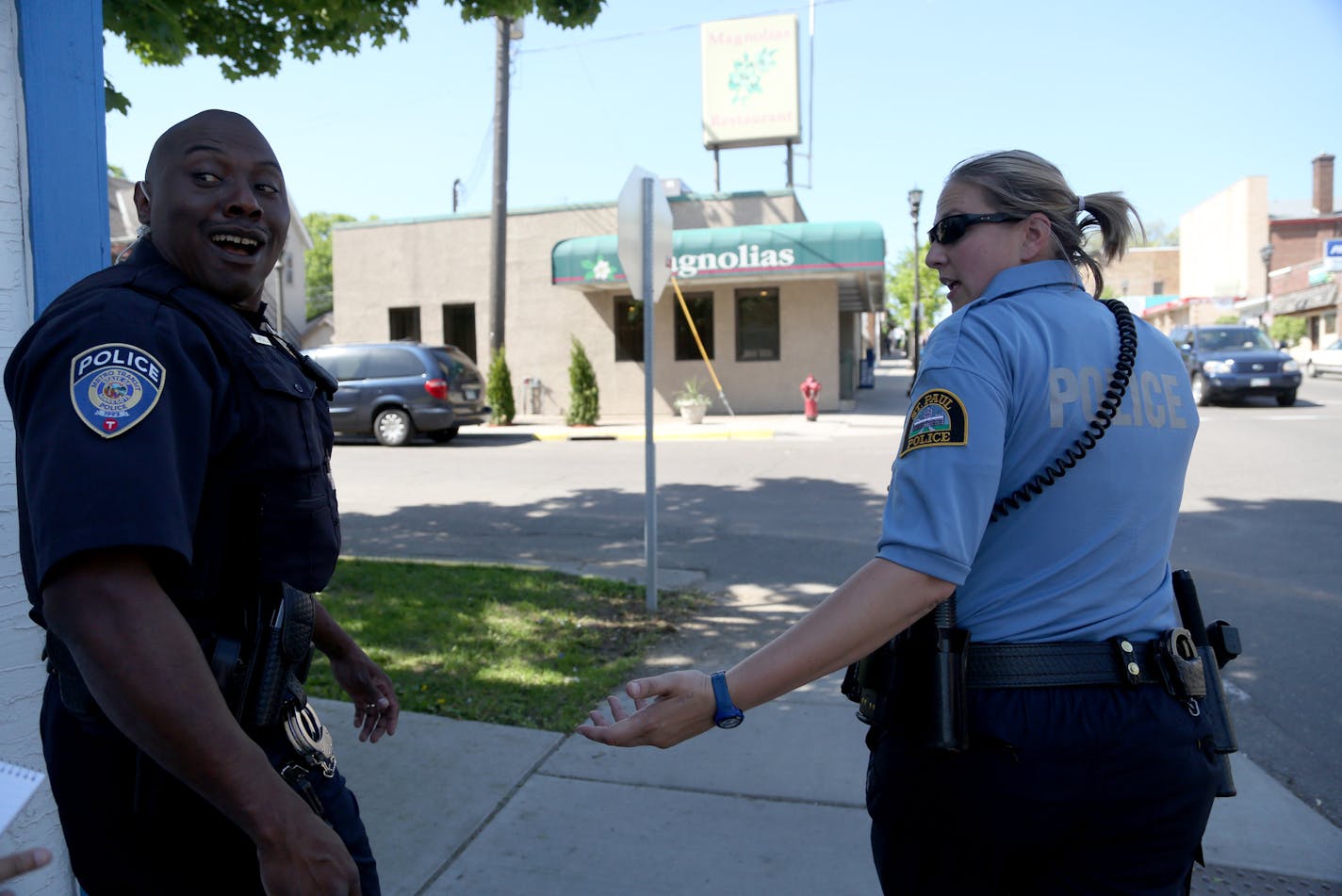 Officers Nicole Carle talked with fellow officer from Metro Transit Leonard Mitchell about what she has seen doing this patrol since April as they walk up Payne Ave. ] (KYNDELL HARKNESS/STAR TRIBUNE) kyndell.harkness@startribune.com Shadowing officers Mitchell and Carle as they walk in the Payne Avenue area in St Paul Min., Friday, May 22, 2015.