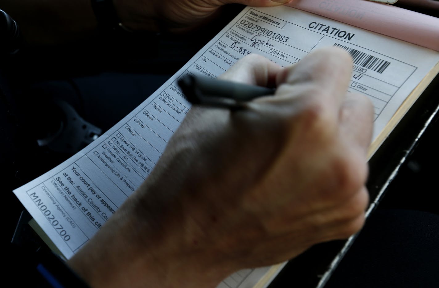 Lino Lakes police officer Adam Halverson wrote up a citation. The printer in his vehicle was not working so he had to handwrite tickets on Monday. Officer Halverson has more than 500 stops in past two months. ] CARLOS GONZALEZ cgonzalez@startribune.com - August 31, 2015, Lino Lakes, MN, Adam Halverson is on his way to becoming the most well-known police officer in Lino Lakes. Lino Lakes new traffic cop who is making waves with more than 500 stop in his first two months.