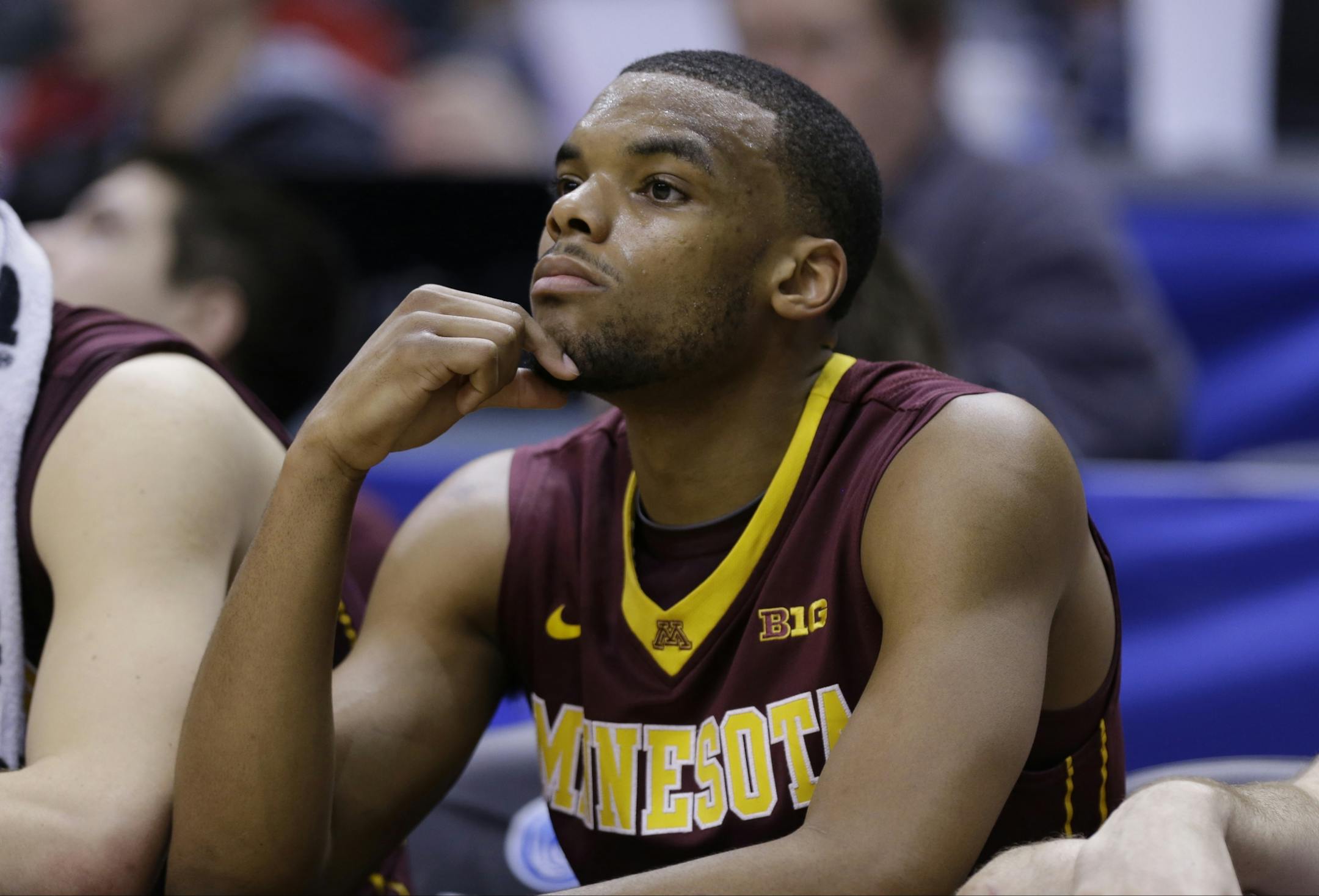 Minnesota guard Andre Hollins watches from the bench in the second half of an NCAA college basketball game against Wisconsin in the quarterfinals of the Big Ten Conference tournament Friday, March 14, 2014, in Indianapolis. Wisconsin won 83-57.