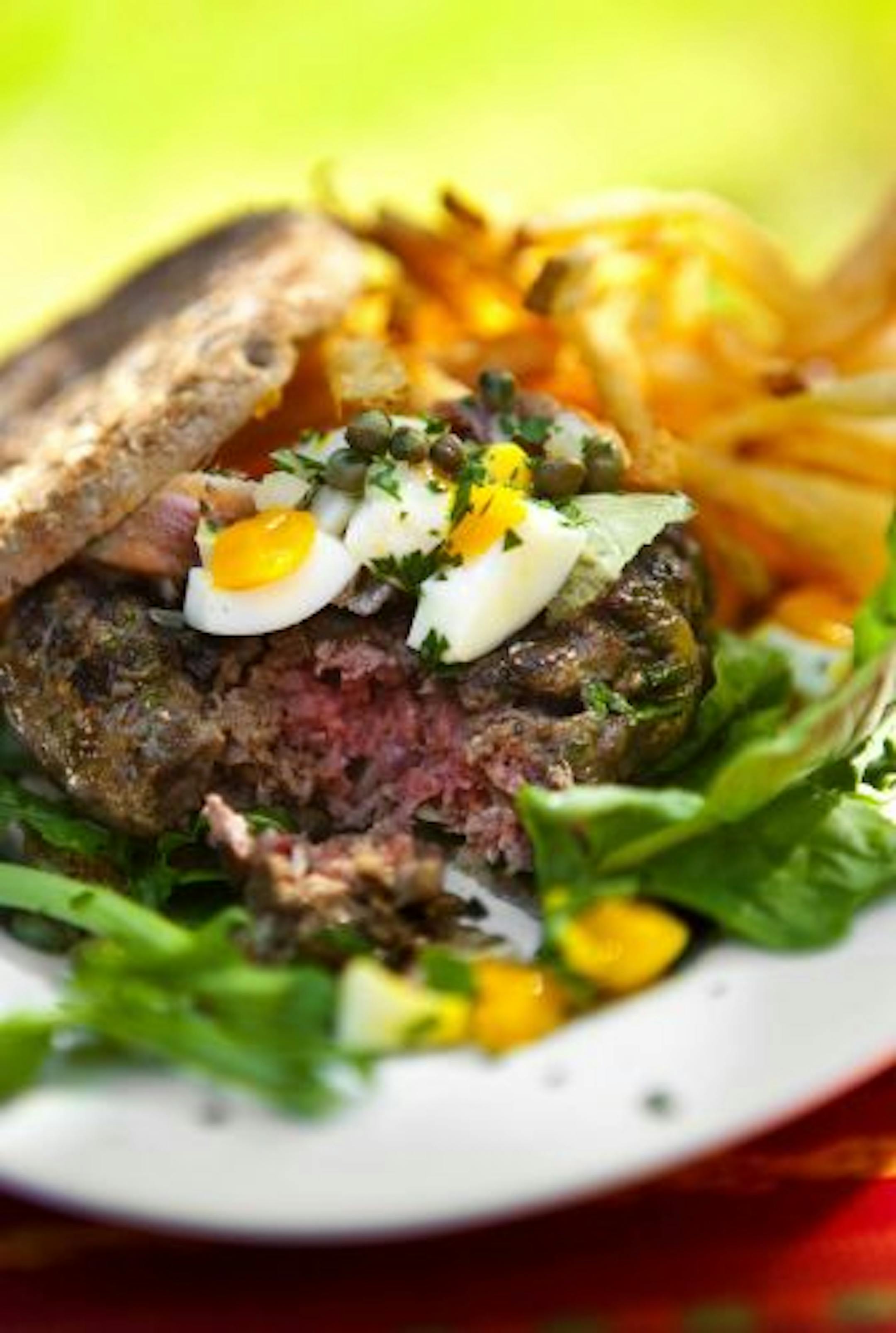 Not your ordinary burger: A beef tartare burger is topped with anchovy fillets and hard-cooked eggs.
