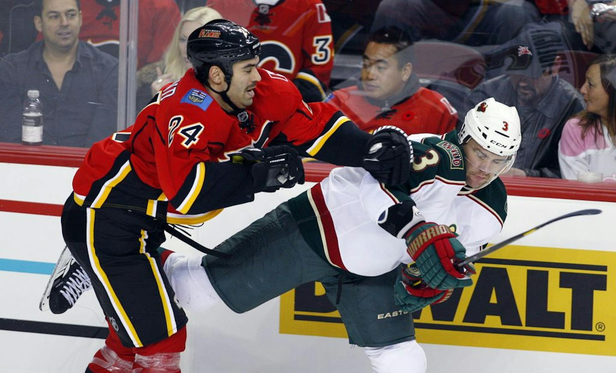 Minnesota Wild Marek Zidlicky, right, takes a hit from Calgary Flames' Pierre-Luc Letourneau-Leblond during second period NHL hockey action in Calgary, Alberta, Tuesday, Nov. 8, 2011.