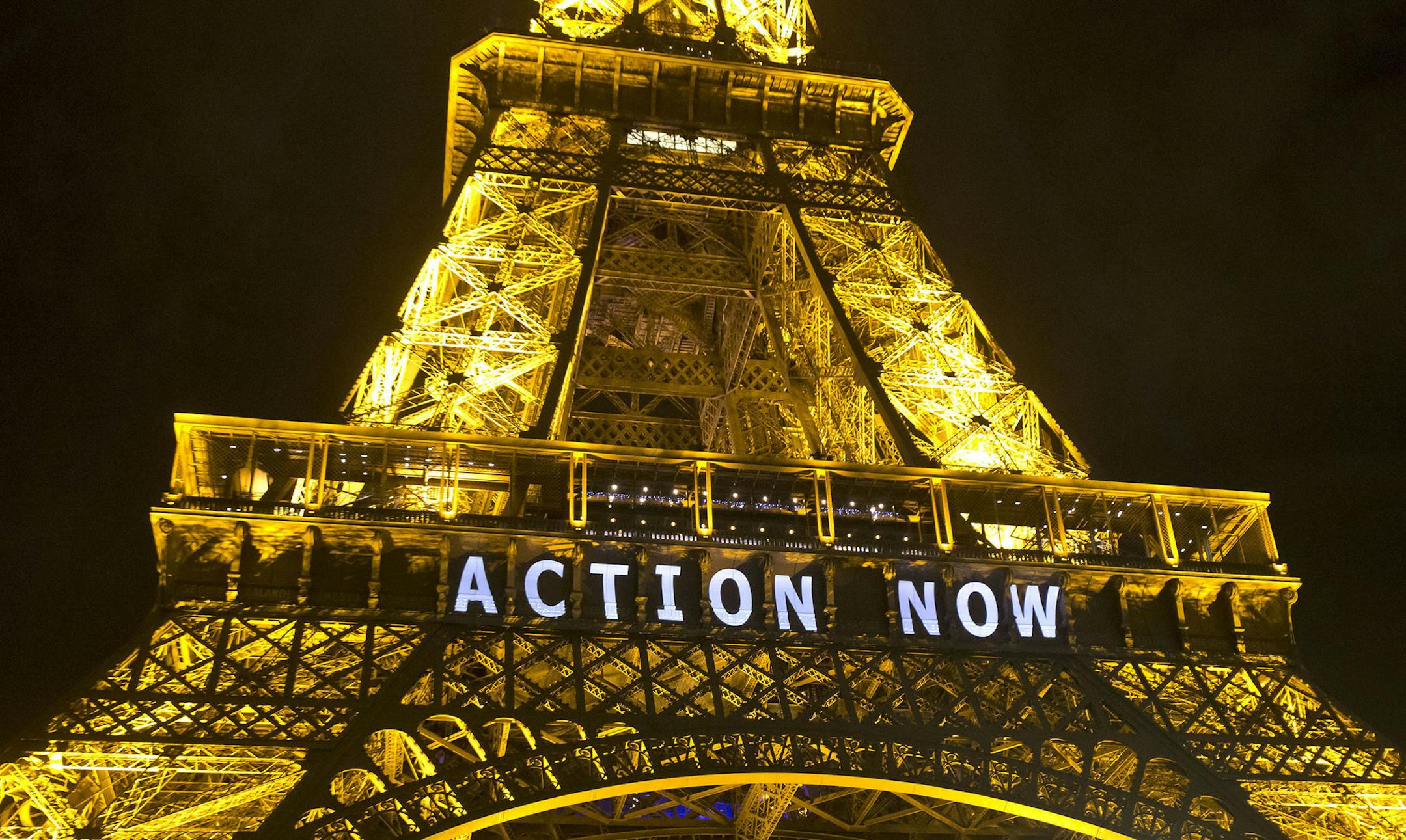 The Eiffel Tower lights up with the slogan"Action Now"referring to the COP21, United Nations Climate Change Conference in Paris, Sunday, Dec. 6, 2015. Negotiators adopted a draft climate agreement Saturday that was cluttered with brackets and competing options, leaving ministers with the job of untangling key sticking points in what is envisioned to become a lasting, universal pact to fight global warming. (AP Photo/Michel Euler) ORG XMIT: MIN2015120713090524