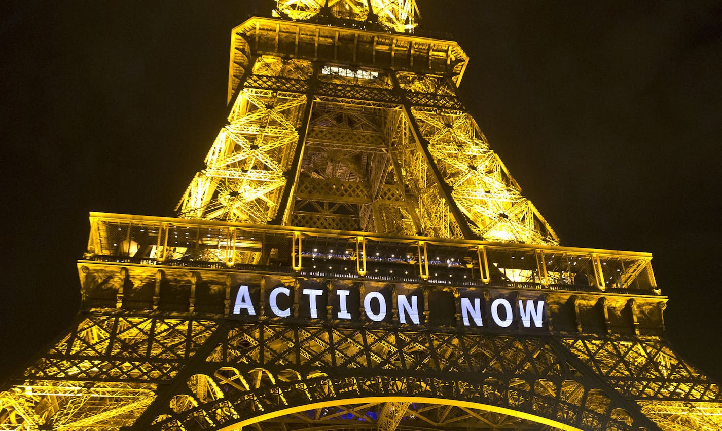 The Eiffel Tower lights up with the slogan"Action Now"referring to the COP21, United Nations Climate Change Conference in Paris, Sunday, Dec. 6, 2015. Negotiators adopted a draft climate agreement Saturday that was cluttered with brackets and competing options, leaving ministers with the job of untangling key sticking points in what is envisioned to become a lasting, universal pact to fight global warming. (AP Photo/Michel Euler) ORG XMIT: MIN2015120713090524