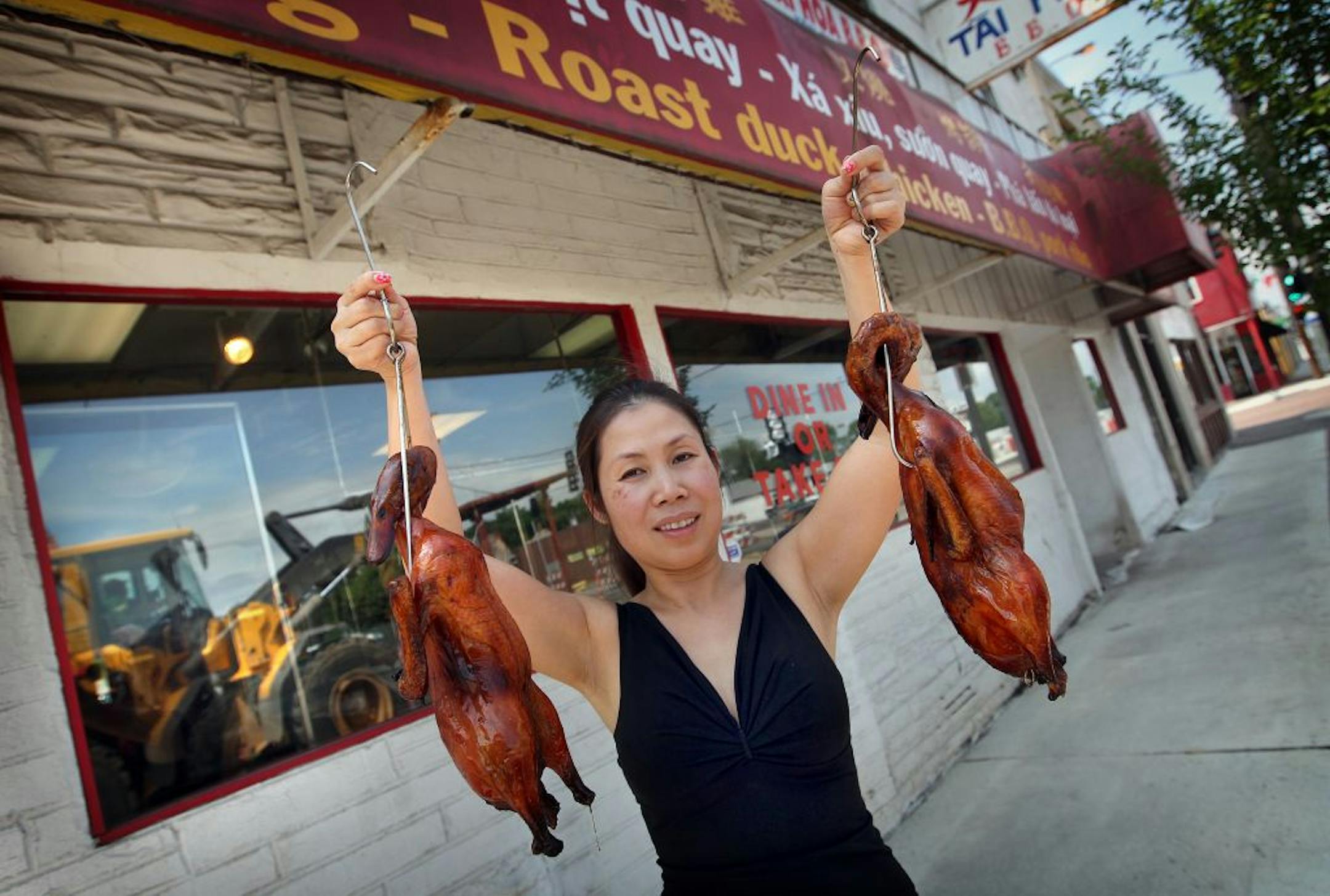 Yen Le Tran holds up Roast Duck. See inloader reflection in window behind her. Tai Hoa BBQ: 854 University Av., 651-298-8480, at Victoria.__A dining guide for University Avenue restaurants/markets being buried under light rail construction, from approximately Victoria St. on the west to Farrington St. on the east.[ TOM WALLACE � twallace@startribune.com _ Assignments #20023887A_ June 7, 2012_ SLUG: rn0614 _ EXTRA INFORMATION: CQ'ed by the subjects