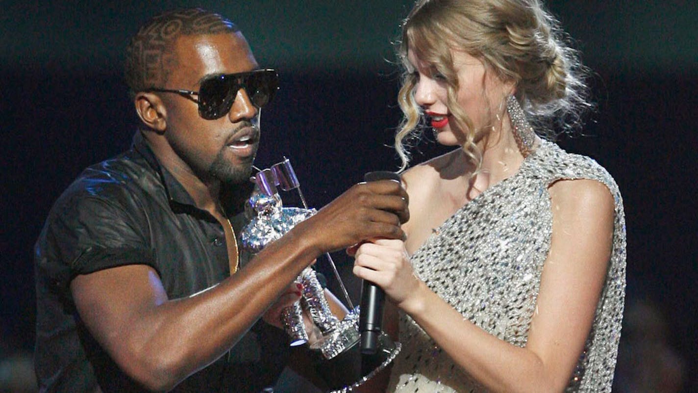 FILE - In this Sept. 13, 2009 file photo, singer Kanye West takes the microphone from singer Taylor Swift as she accepts the "Best Female Video" award during the MTV Video Music Awards in New York. (AP Photo/Jason DeCrow, file)