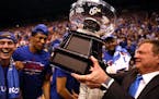 Head coach Bill Self of the Kansas Jayhawks hands the the Big 12 Championship Trophy to players after Kansas defeated the TCU Horned Frogs to win the 