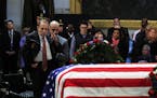 Former Sen. Bob Dole salutes the flag-draped casket containing the remains of former President George H.W. Bush as he lies in state at the U.S. Capito