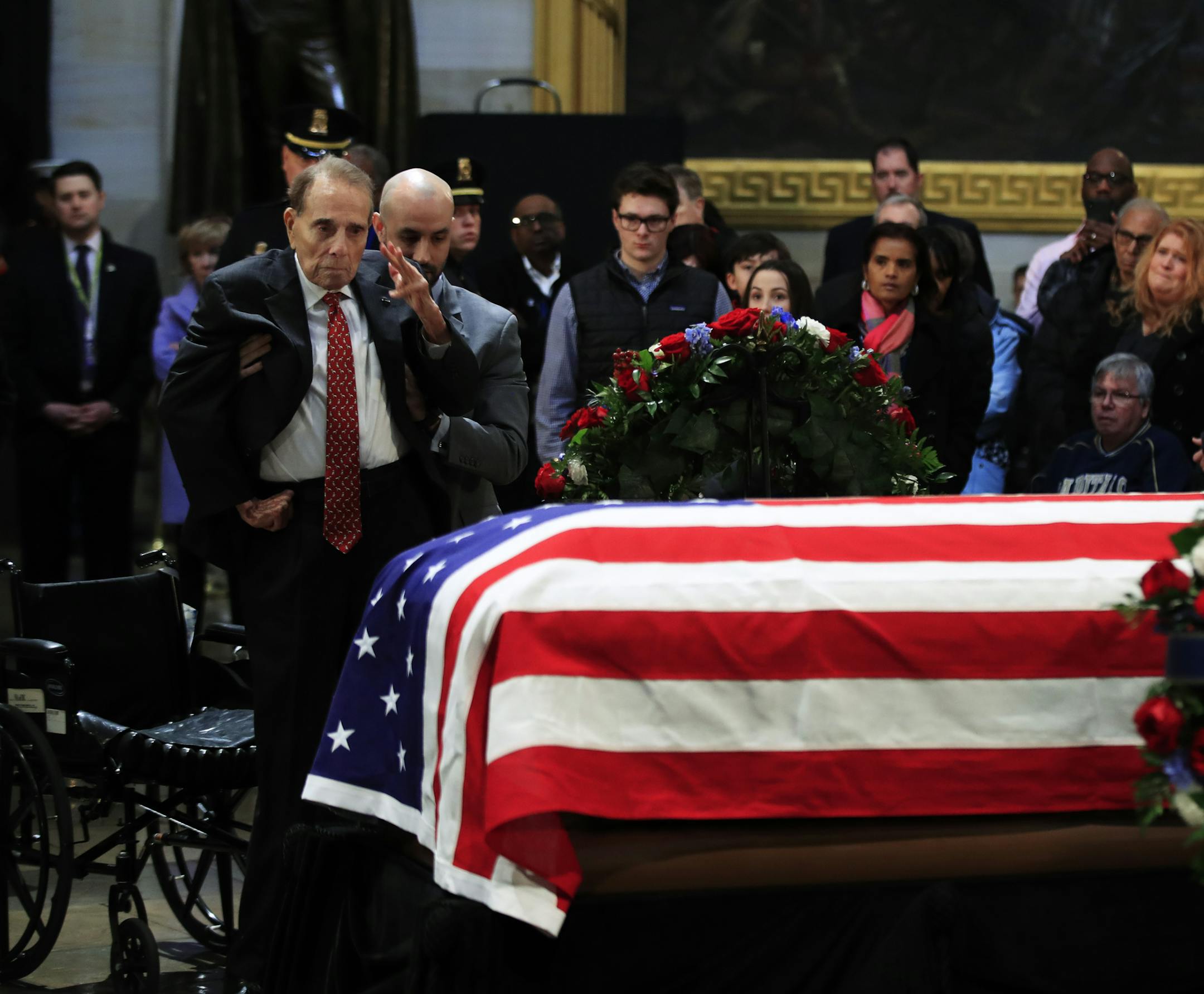 Former Sen. Bob Dole salutes the flag-draped casket containing the remains of former President George H.W. Bush as he lies in state at the U.S. Capitol in Washington, Tuesday, Dec. 4, 2018. (AP Photo/Manuel Balce Ceneta)