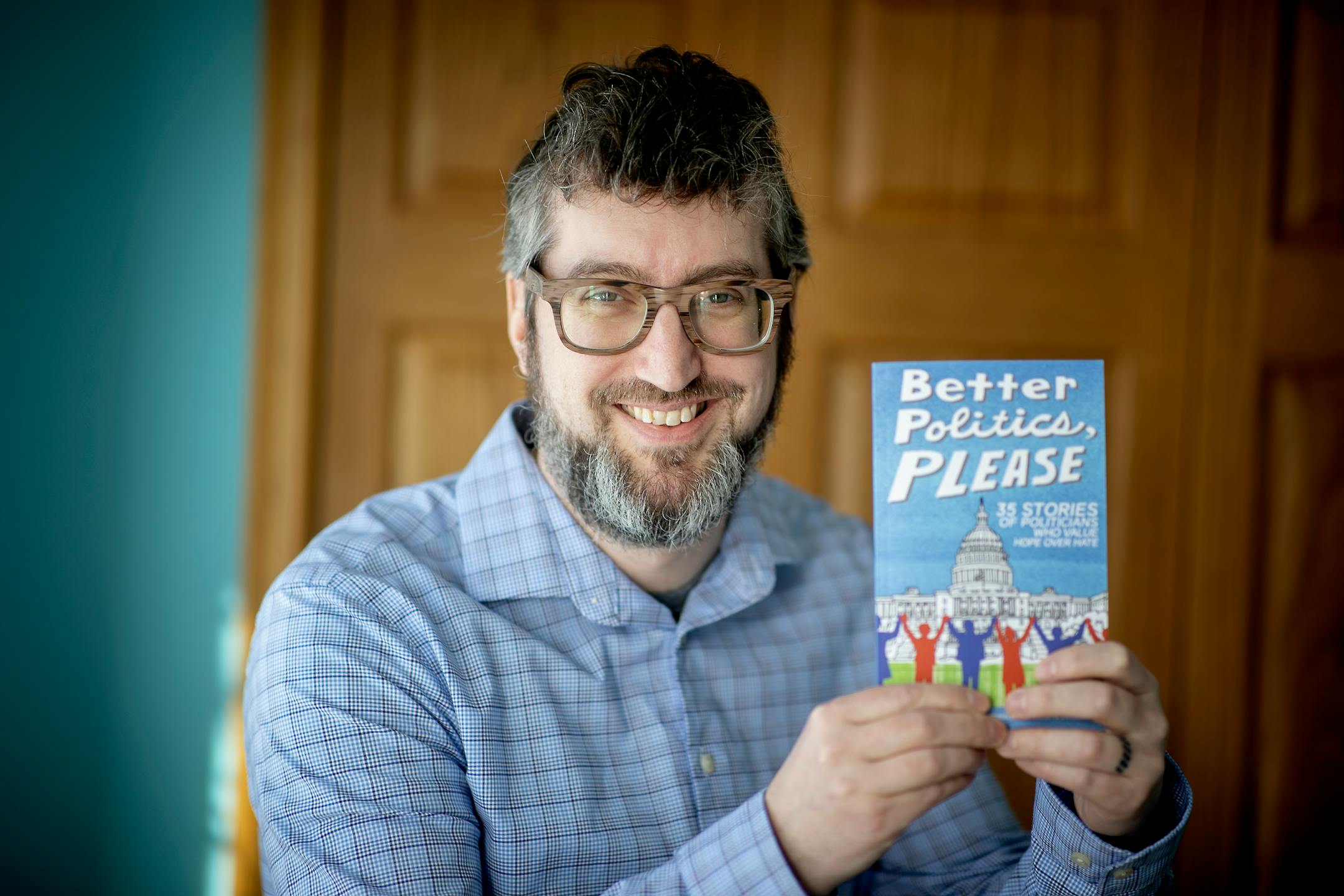 Kevin Hendricks held up a book he wrote titled "Better Politics, Please," at his home Tuesday, January 5, 2021 in St. Paul, MN. The book was written to encourage people to view the new year with more decency. ] ELIZABETH FLORES • liz.flores@startribune.com