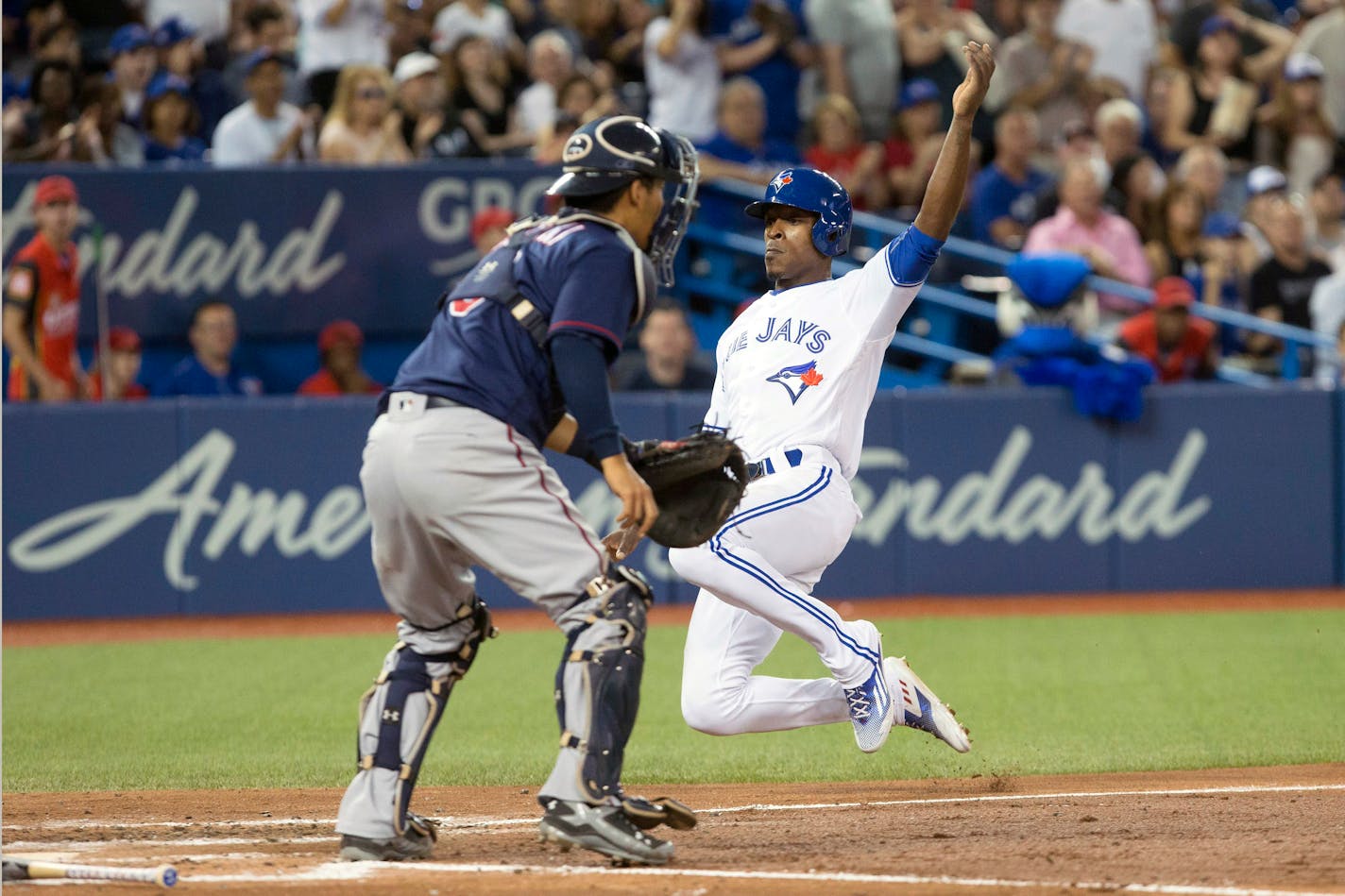 Toronto Blue Jays' Melvin Upton Jr., right, slides into home plate in front of Minnesota Twins catcher Kurt Suzuki after Justin Smoak hit an RBI-single off Minnesota Twins starting pitcher Pat Dean during third-inning baseball game action in Toronto, Friday, Aug. 26, 2016. (Chris Young/The Canadian Press via AP)