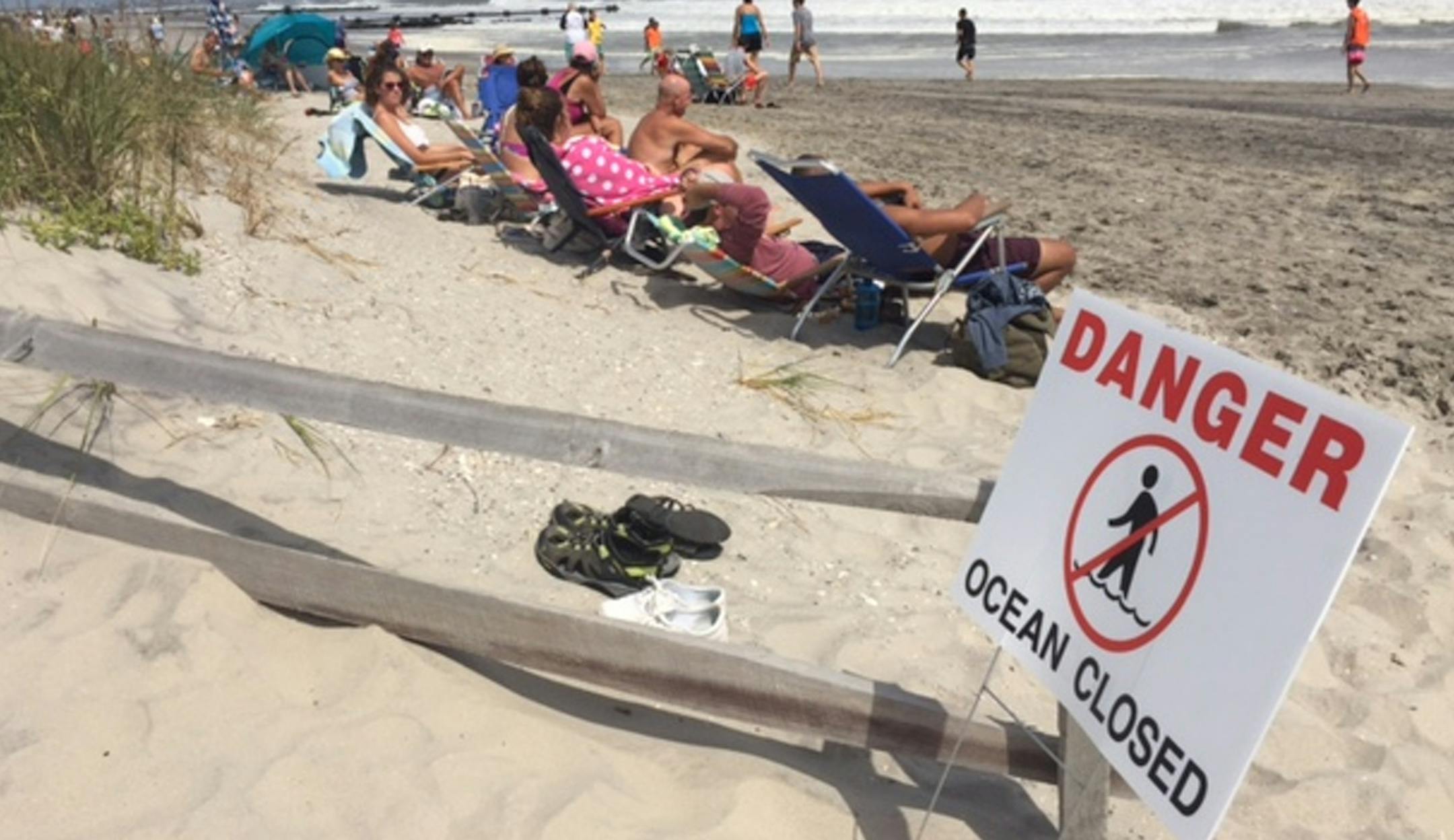 People sit at the beach in Ocean City, N.J., on Sunday, Sept. 4, 2016. Storm system Hermine spun away from the U.S. East Coast on Sunday, removing the threat of heavy rain but maintaining enough power to churn dangerous waves and currents — and keep beaches off-limits to disappointed swimmers and surfers during the holiday weekend. (Viviana Pernot /The Press of Atlantic City via AP)