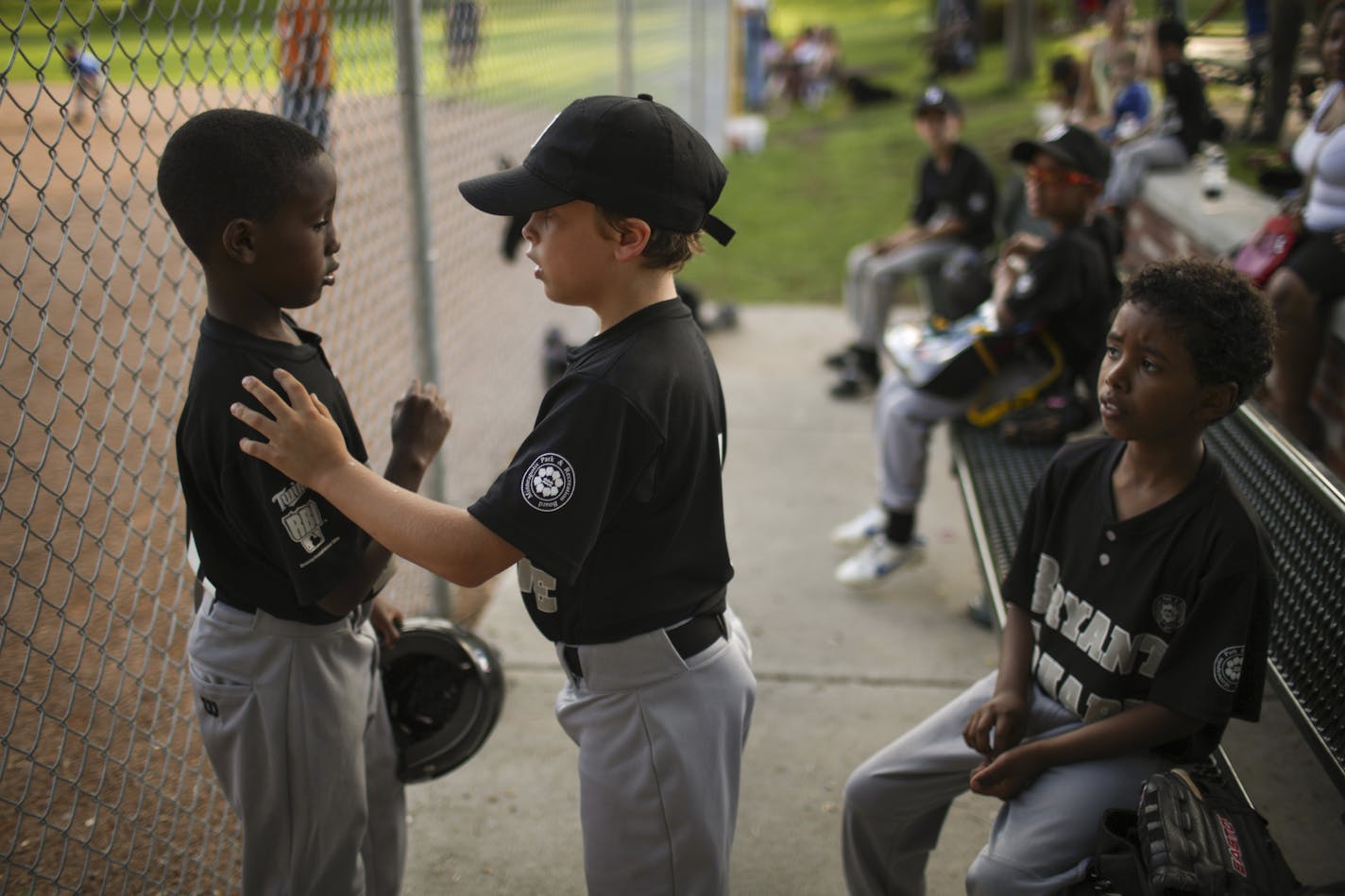 Khy Paradis, 9, center, offered support to Imraan Arale, 9, after his at bat against Kenwood-Bryn Mawr last month at Bryant Square Park. Ashraf Mohamed, 9, was on the bench at right. ] JEFF WHEELER &#x2022; jeff.wheeler@startribune.com The Bryant Square Park rec center little league team had a game on their home field Wednesday night, June 18, 2014.