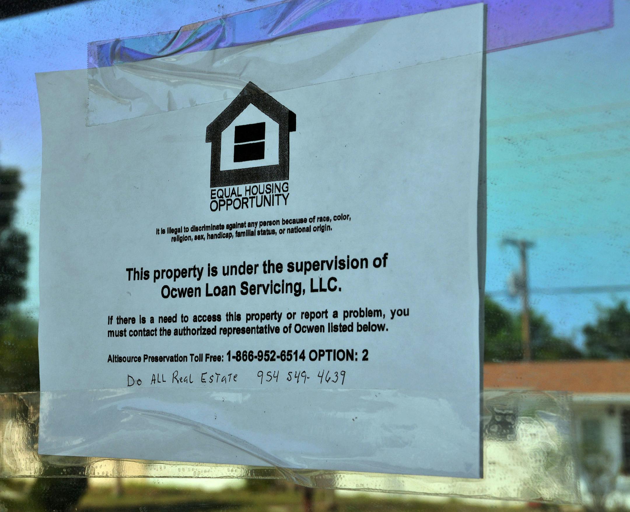 An equal housing opportunity sign is taped to the window of a bank-owned home in Lantana, Florida, U.S., on Wednesday, March 30, 2011. Letting homeowners unload properties for less than their mortgage debt may stem home-price declines by preventing foreclosures, which drag down overall values by selling at discounts. The problem is short sales are rising at about half the pace of home seizures as a lengthy consent process by loan holders deters potential buyers. Photographer: Mark Elias/Bloomber
