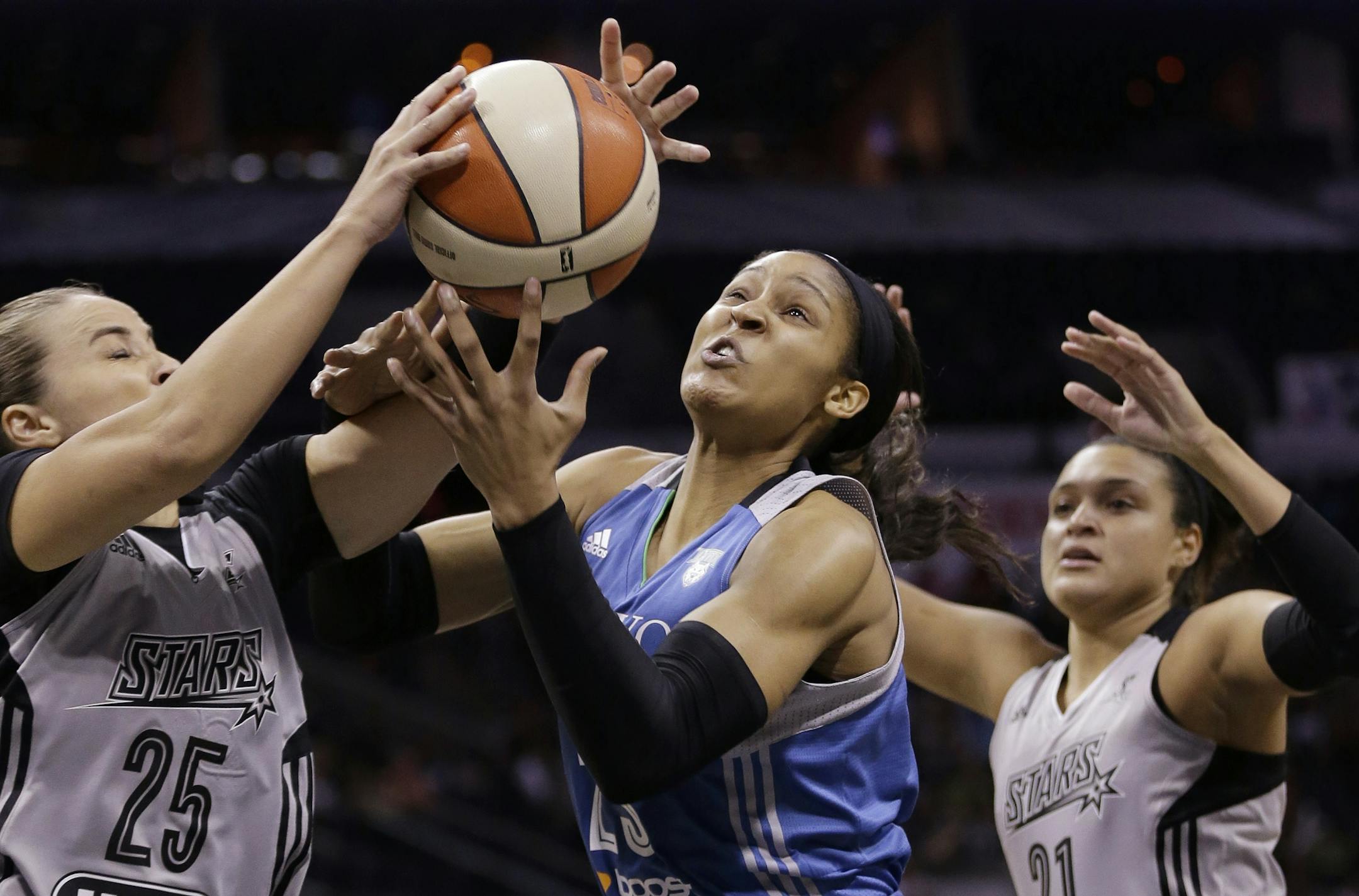 San Antonio Stars' Becky Hammon (25) steals the ball from Minnesota Lynx's Maya Moore, center, during the first half in Game 2 of the WNBA basketball Western Conference semifinal, Saturday, Aug. 23, 2014, in San Antonio. Stars' Kayla McBride, right, assists on the play.
