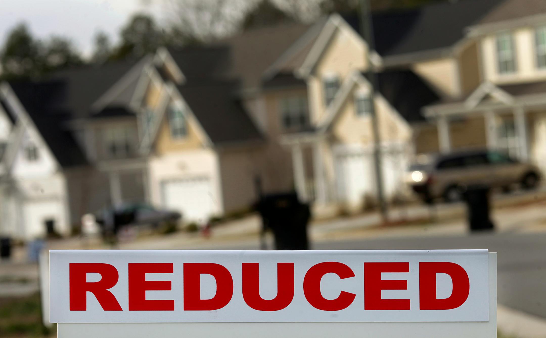 A reduced sign is displayed in front of a house for sale outside of Greensboro, North Carolina, U.S., on Monday, Feb. 13, 2012. The National Association of Realtors is scheduled to release existing homes data on Feb. 22. Photographer: Victor J. Blue/Bloomberg