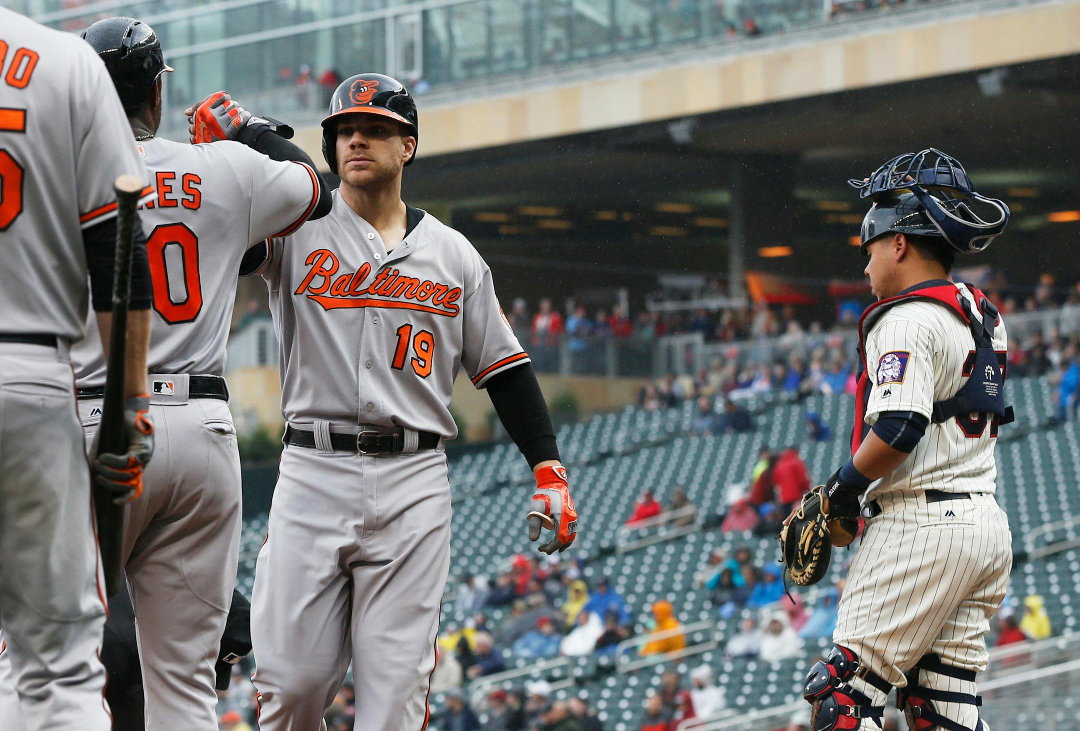 Baltimore Orioles' Chris Davis (19) is congratulated by teammates following his two-run home run off Minnesota Twins pitcher Phil Hughes in the fourth inning of a baseball game Wednesday, May 11, 2016, in Minneapolis. Not watching, right, is Twins catcher Juan Centeno. (AP Photo/Jim Mone)