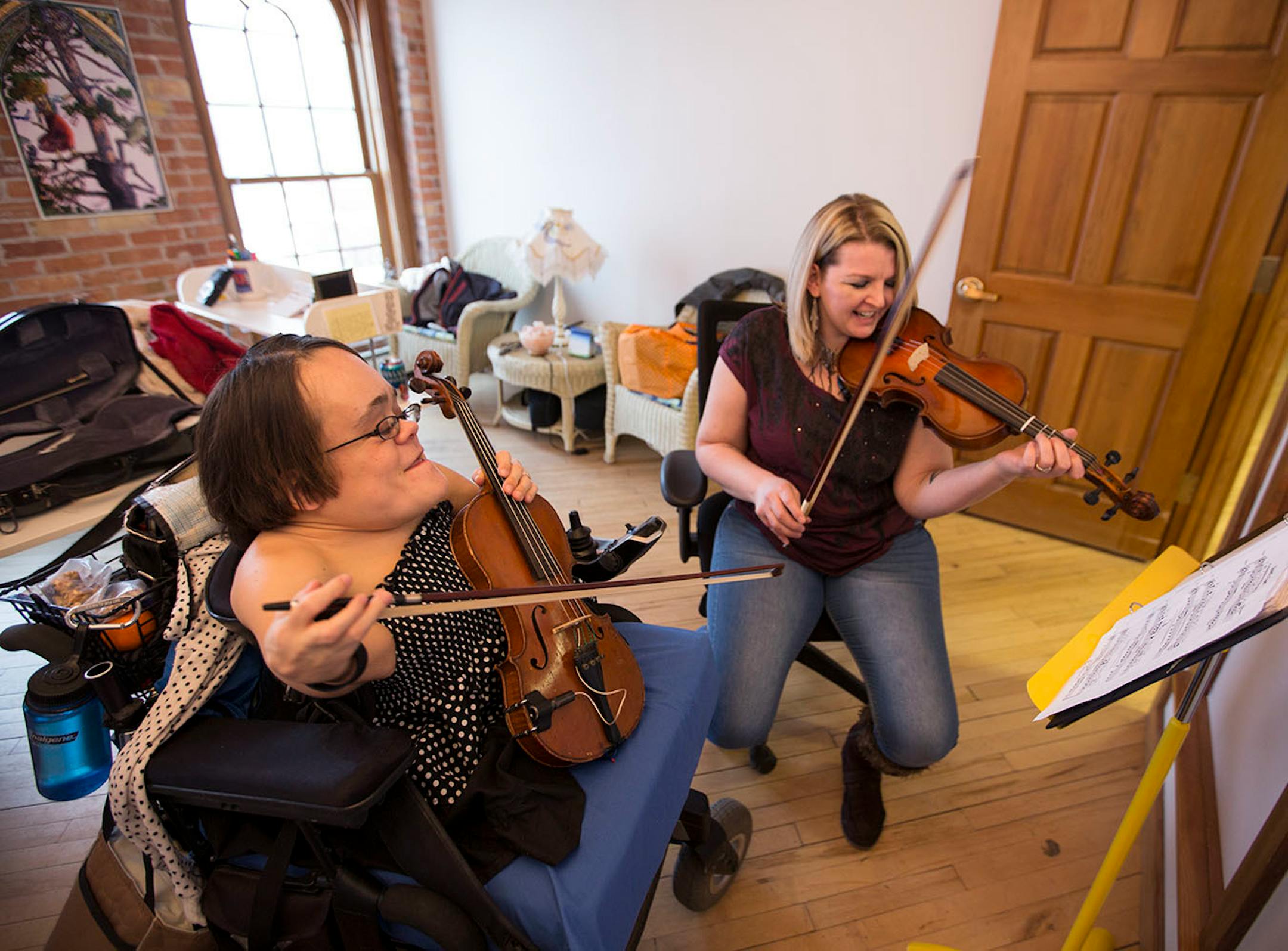 The winner of NPR's Tiny Desk contest, Gaelynn Lea, left, gave fiddle lessons to Christina Taylor at her studio in Duluth.