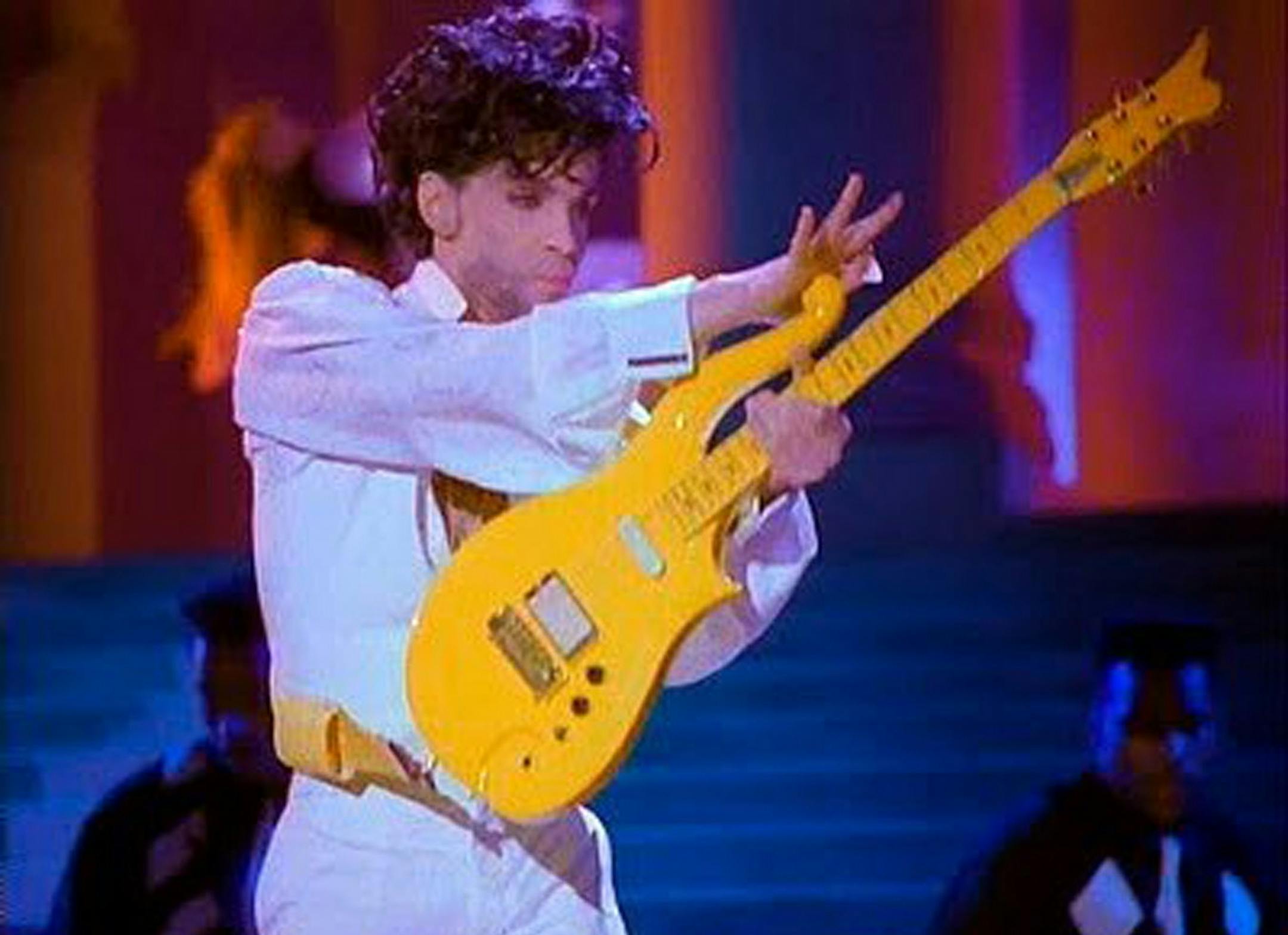 This photo provided by Heritage Auctions shows Prince playing his Yellow Cloud electric guitar. Indianapolis Colts owner Jim Irsay has purchased the Yellow Cloud electric guitar that Prince used in numerous concerts until the mid-1990's. The NFL football team owner and collector of musical instruments paid $137,500 for the guitar at an auction in Beverly Hills Saturday, June 25, 2016. Heritage Auctions, which conducted the auction, says the solid body guitar was a favorite of the late musician f