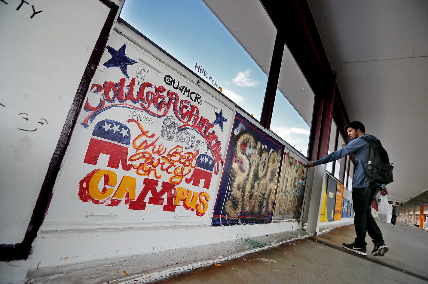 Dan Kreft, a senior psychology major at the University of Minnesota, showed a friend some graffiti that is rousing controversy over a "build the wall" message that university college Republicans painted on the Washington Avenue bridge, and others painted over, Tuesday, October 4, 2016 in Minneapolis, MN. ] (ELIZABETH FLORES/STAR TRIBUNE) ELIZABETH FLORES &#x2022; eflores@startribune.com