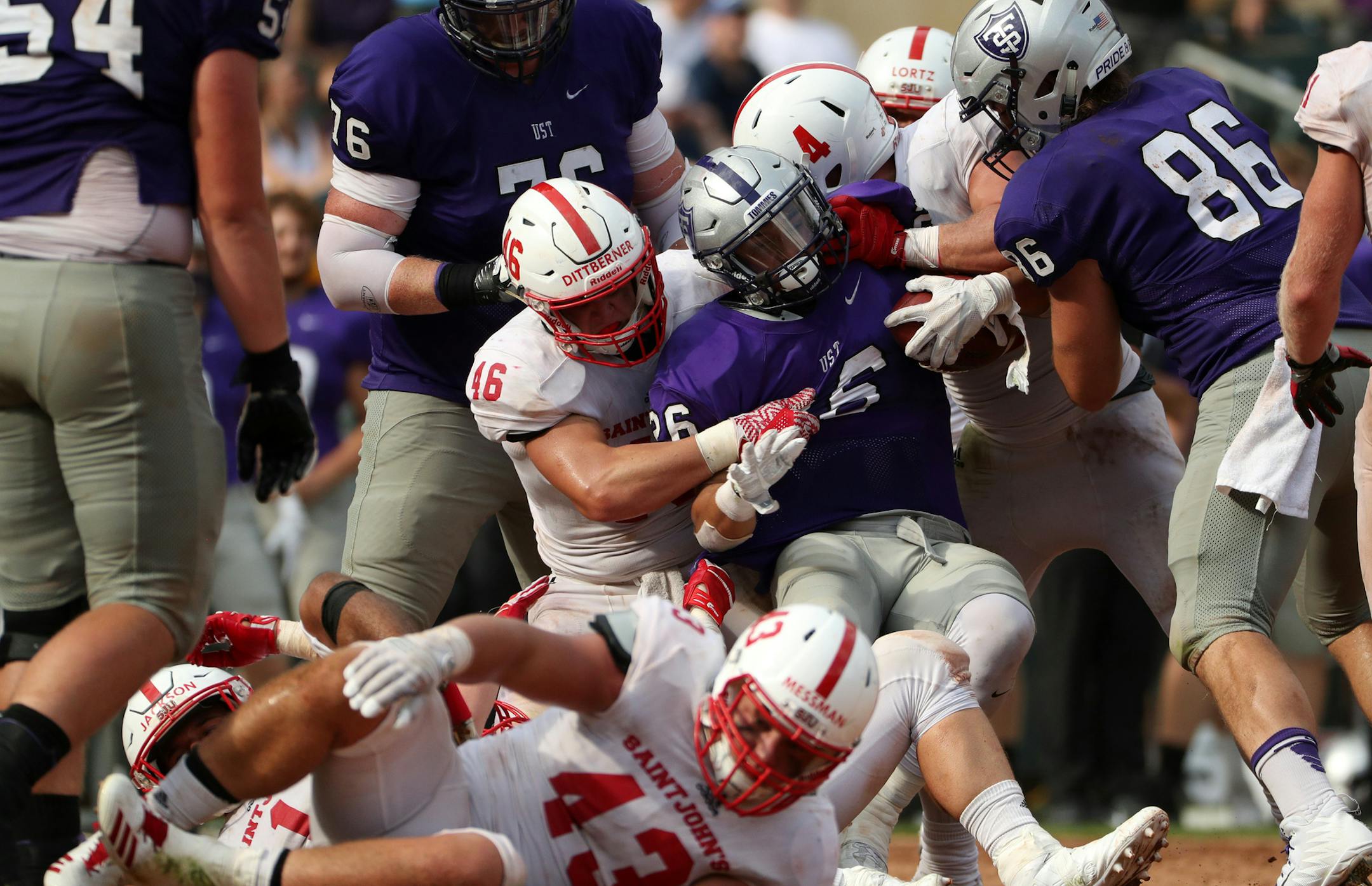 University of St. Thomas running back Josh Parks (26) was pulled down by St. John's University defensive lineman Trevor Dittberner (46) in the second half. ] ANTHONY SOUFFLE • anthony.souffle@startribune.com Game action from an NCAA football game between the University of St. Thomas and St. John's University Saturday, Sept. 23, 2017 at Target Field in Minneapolis. ORG XMIT: MIN1709231707130197 ORG XMIT: MIN1812041723172543