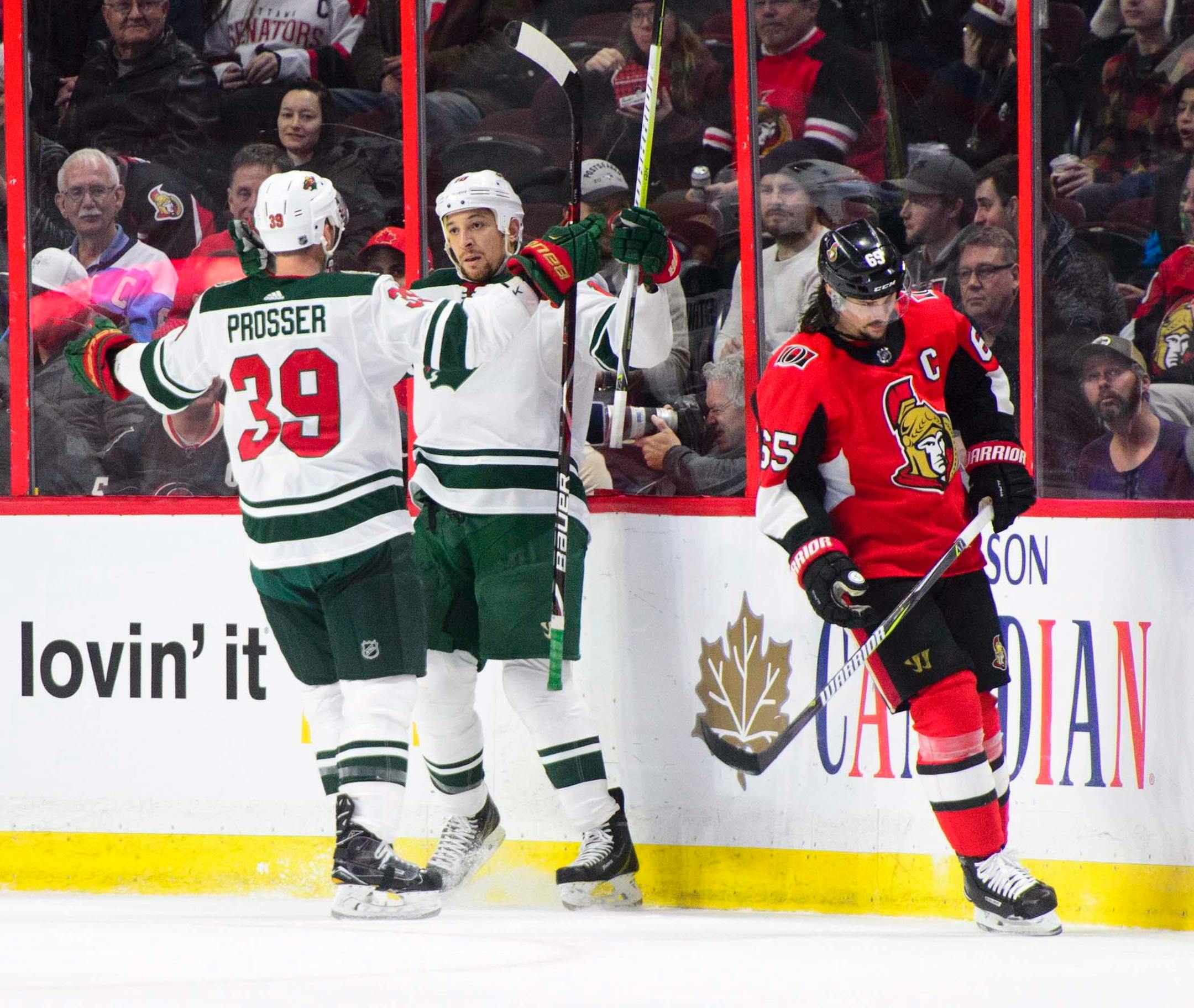 Minnesota Wild's Chris Stewart, center, and Nate Prosser celebrate a goal as Ottawa Senators' Erik Karlsson skates past during second period NHL hockey action in Ottawa on Tuesday, Dec. 19, 2017. (Sean Kilpatrick/The Canadian Press via AP)
