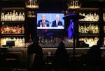 People in West Hollywood, Calif., watch a broadcast of a presidential debate between Donald Trump and Joe Biden on Oct. 22, 2020.
