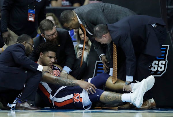 Trainers assist Auburn's Chuma Okeke after he was injured during the second half vs. North Carolina. Okeke tore the ACL in his knee and will undergo s