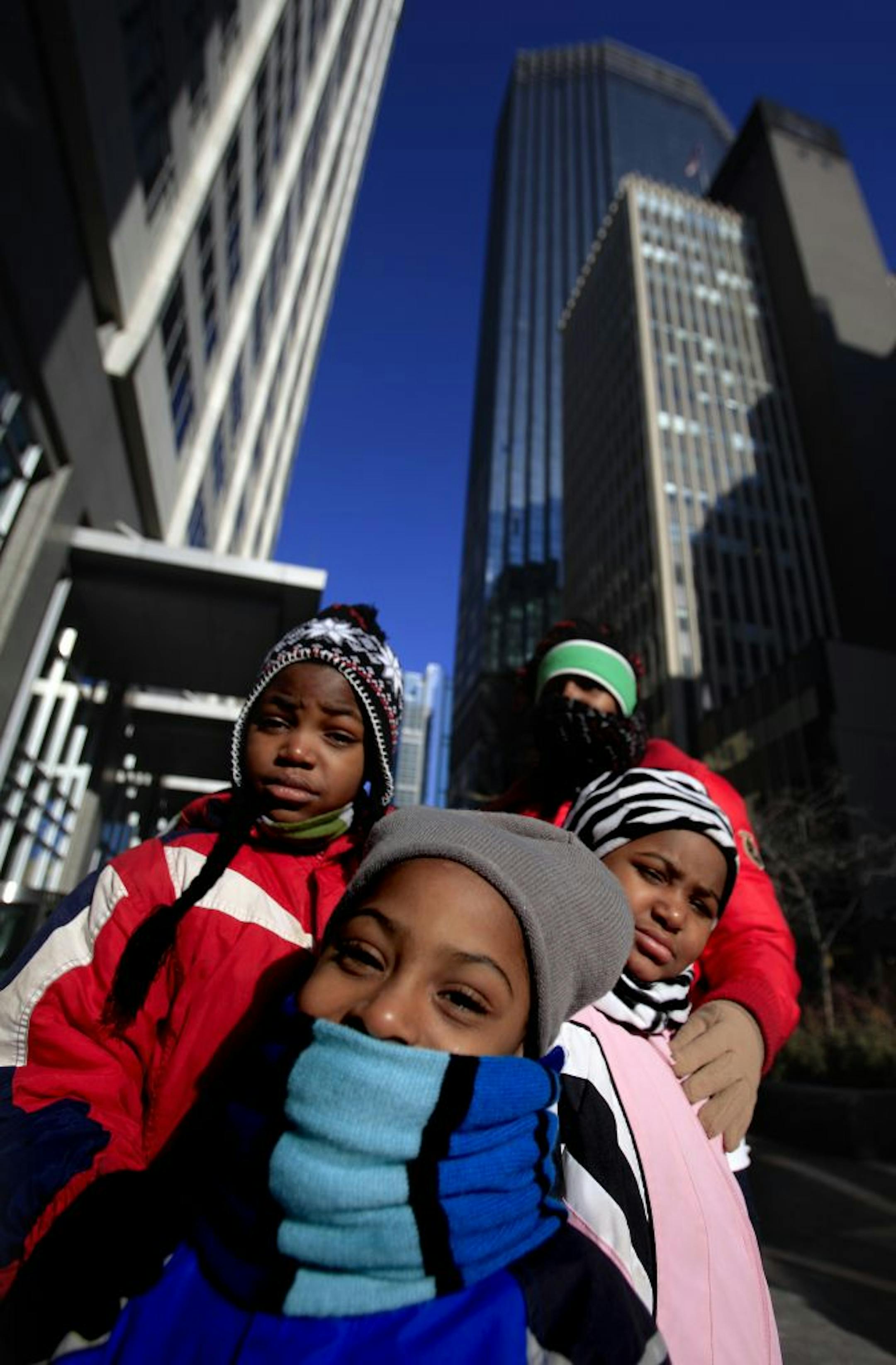 Jasmine Brown and her kids, from left, Cortez, Anthony and Damarionna were bundled up — hats and headgear included — against the cold Monday as they waited for a bus in Minneapolis.