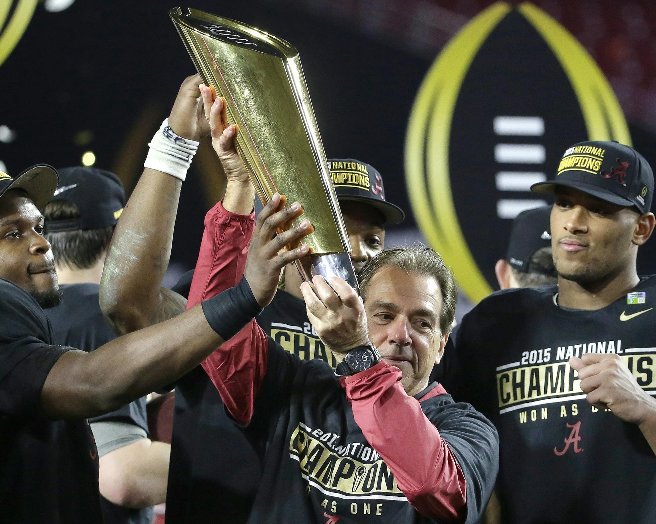 Alabama football coach Nick Saban held up the championship trophy with his players after beating Clemson 45-40 for the NCAA college football playoff championship on Monday.