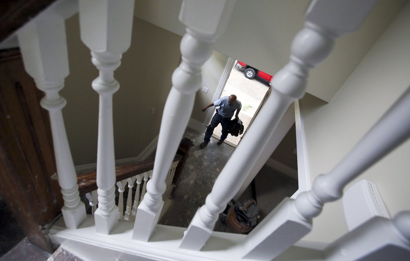 Seen through the spindles of the original staircase and handrails, Plumber Lee Cesar of Berg Plumbing and Heating carries in tools as he prepares to set a toilet into place in one of four formerly rundown properties in the Dayton's Bluff historic district that have been restored or are in the process Thursday, Aug. 1, 2013.](DAVID JOLES/STARTRIBUNE) djoles@startribune.com Four years ago, St. Paul stuck its neck out to buy 11 rundown properties in the Dayton's Bluff historic district of little in