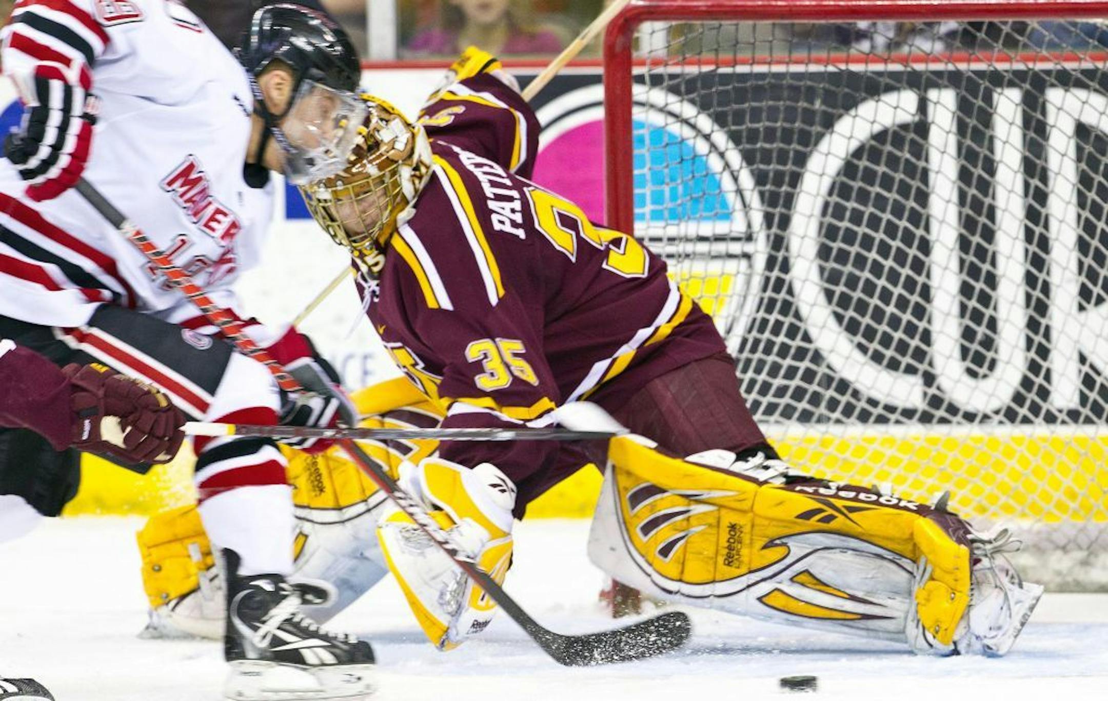 Nebraska-Omaha's Ryan Walters, left, shoots against Minnesota goalie Kent Patterson during the first period of a college hockey game in Omaha, Neb., Saturday, Feb. 25, 2012.