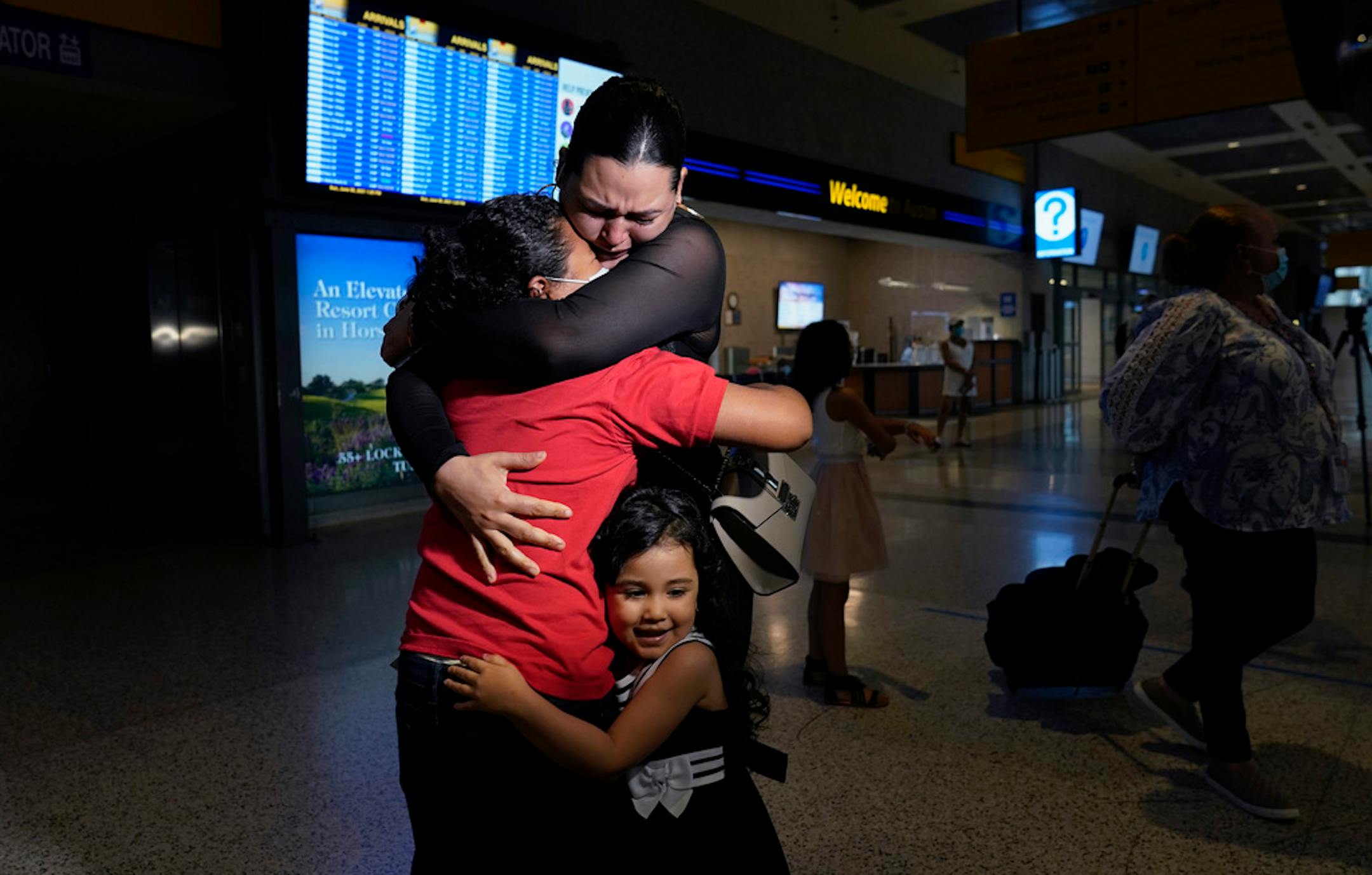 Emely, left, is reunited with her mother, Glenda Valdez and sister, Zuri, at Austin-Bergstrom International Airport, Sunday, June 6, 2021, in Austin, Texas. It had been six years since Valdez said goodbye to her daughter Emely in Honduras. Then, last month, she caught a glimpse of a televised Associated Press photo of a little girl in a red hoodie and knew that Emely had made the trip alone into the United States. On Sunday, the child was returned to her mother's custody. (AP Photo/Eric Gay)