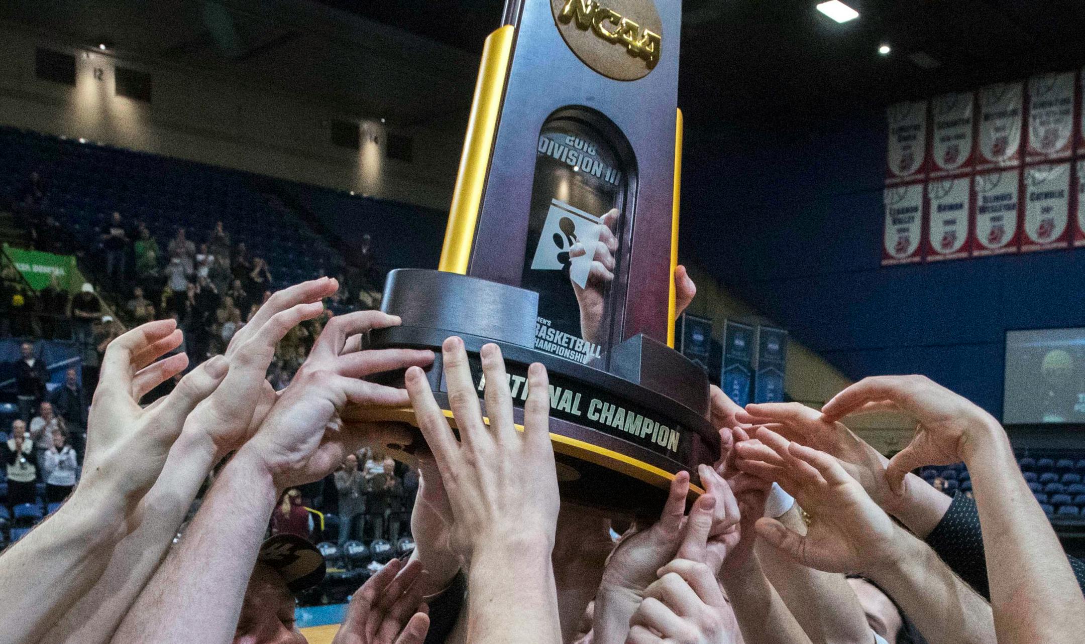 Nebraska Wesleyan players celebrate with the championship trophy after winning the NCAA men's Division III championship college basketball game against Wisconsin-Oshkosh at Salem Civic Center in Salem, Va., Saturday, March 17, 2018. Nebraska Wesleyan won 78-72. (AP Photo/Don Petersen)
