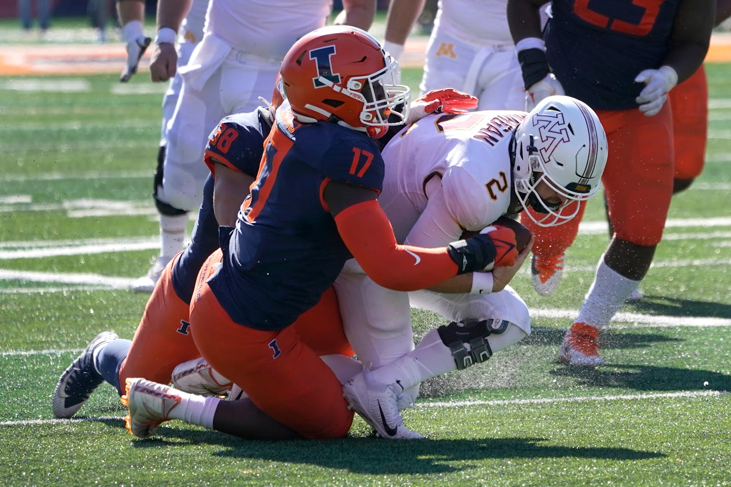 Minnesota quarterback Tanner Morgan is tackled by Illinois linebacker Isaac Darkangelo (38) and Gabe Jacas (17) during the second half of an NCAA college football game Saturday, Oct. 15, 2022, in Champaign, Ill. Morgan was injured on the play and did not return. (AP Photo/Charles Rex Arbogast)