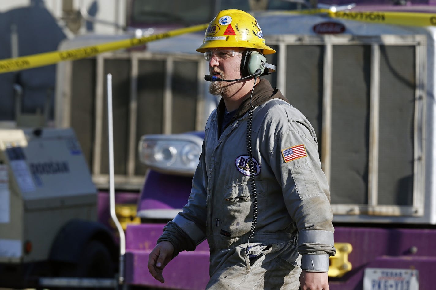 In this March 25, 2014 photo, Mike Hamilton, ground and crew supervisor for Bayou Well Services, keeps watch over a hydraulic fracturing operation at an Encana Corp. well pad near Mead, Colo. It takes a few weeks for the half dozen wells on a typical pad to be fracked, after which the petroleum products are extracted for years by operators like Encana. (AP Photo/Brennan Linsley)