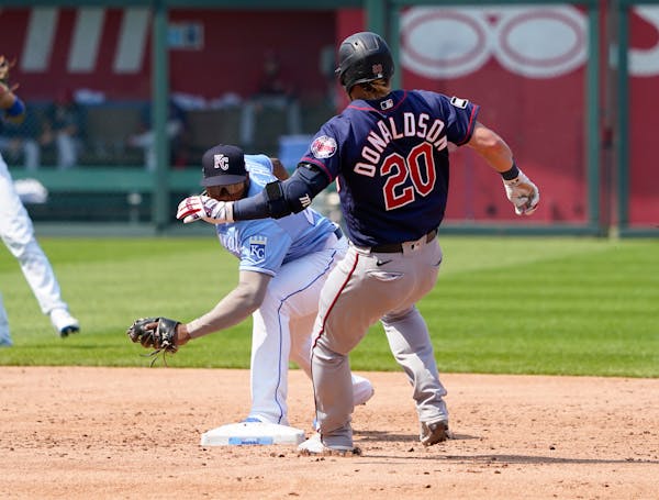 Minnesota Twins' Josh Donaldson (20) beats the tag by Kansas City Royals second baseman Hanser Alberto for a double in the third inning during a baseb