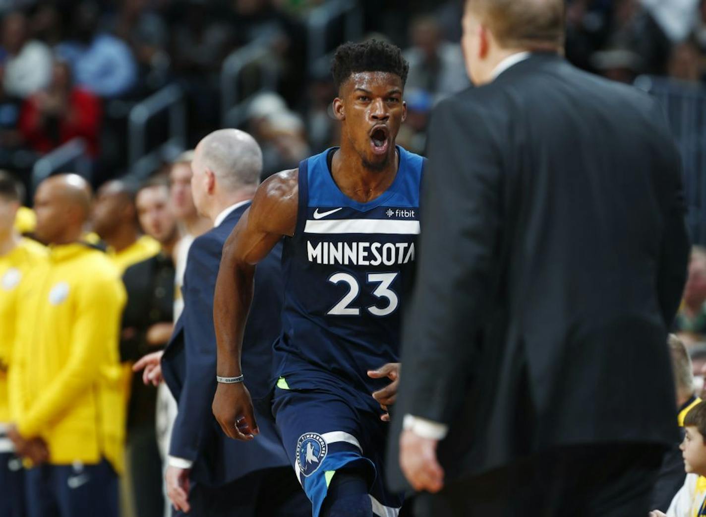 Timberwolves guard Jimmy Butler (23) runs back to the bench and head coach Tom Thibodeau during a game in December.