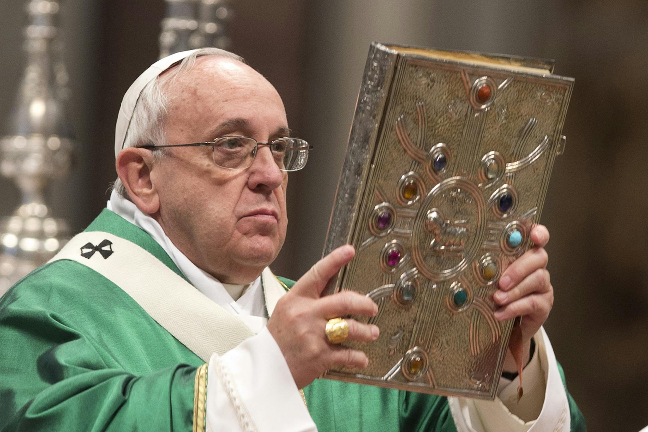Pope Francis holds the Gospels book as he celebrates a Mass for newly-elected cardinals, in St. Peter's Basilica at the Vatican, Sunday, Feb. 15, 2015. Pope Francis welcomed 20 new cardinals Saturday into the elite club of churchmen who will elect his successor and immediately delivered a tough-love message to them, telling them to put aside their pride, jealousy and self-interests and instead exercise perfect charity. (AP Photo/Andrew Medichini)