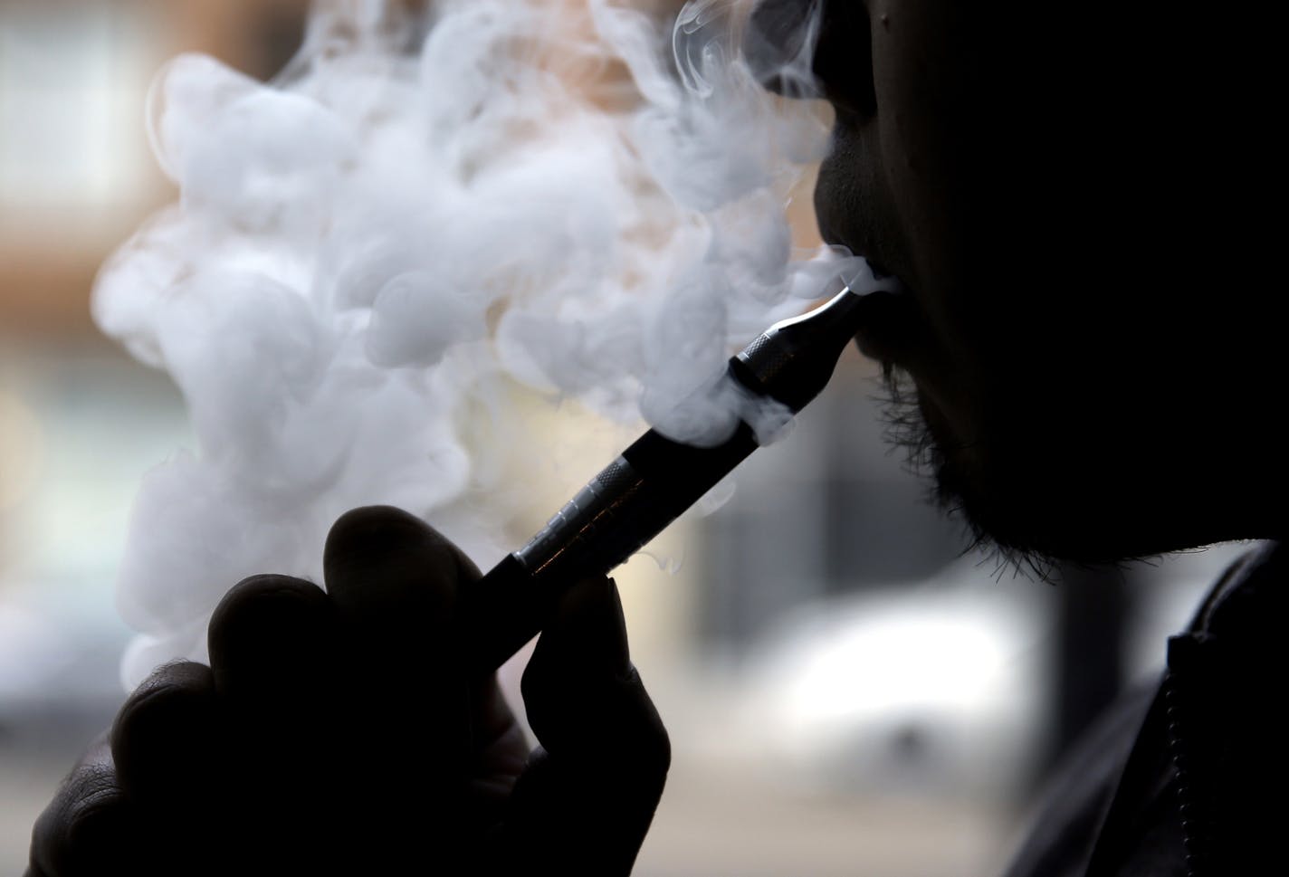 Daryl Cura demonstrates an e-cigarette at Vape store in Chicago, Wednesday, April 23, 2014. The federal government wants to ban sales of electronic cigarettes to minors and require approval for new products and health warning labels under regulations being proposed by the Food and Drug Administration. (AP Photo/Nam Y. Huh) ORG XMIT: MIN2014042911470825