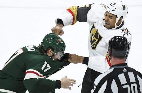 Vegas Golden Knights right wing Ryan Reaves (75) and Minnesota Wild left wing Marcus Foligno (17) fought in the third period Saturday night. ] AARON L