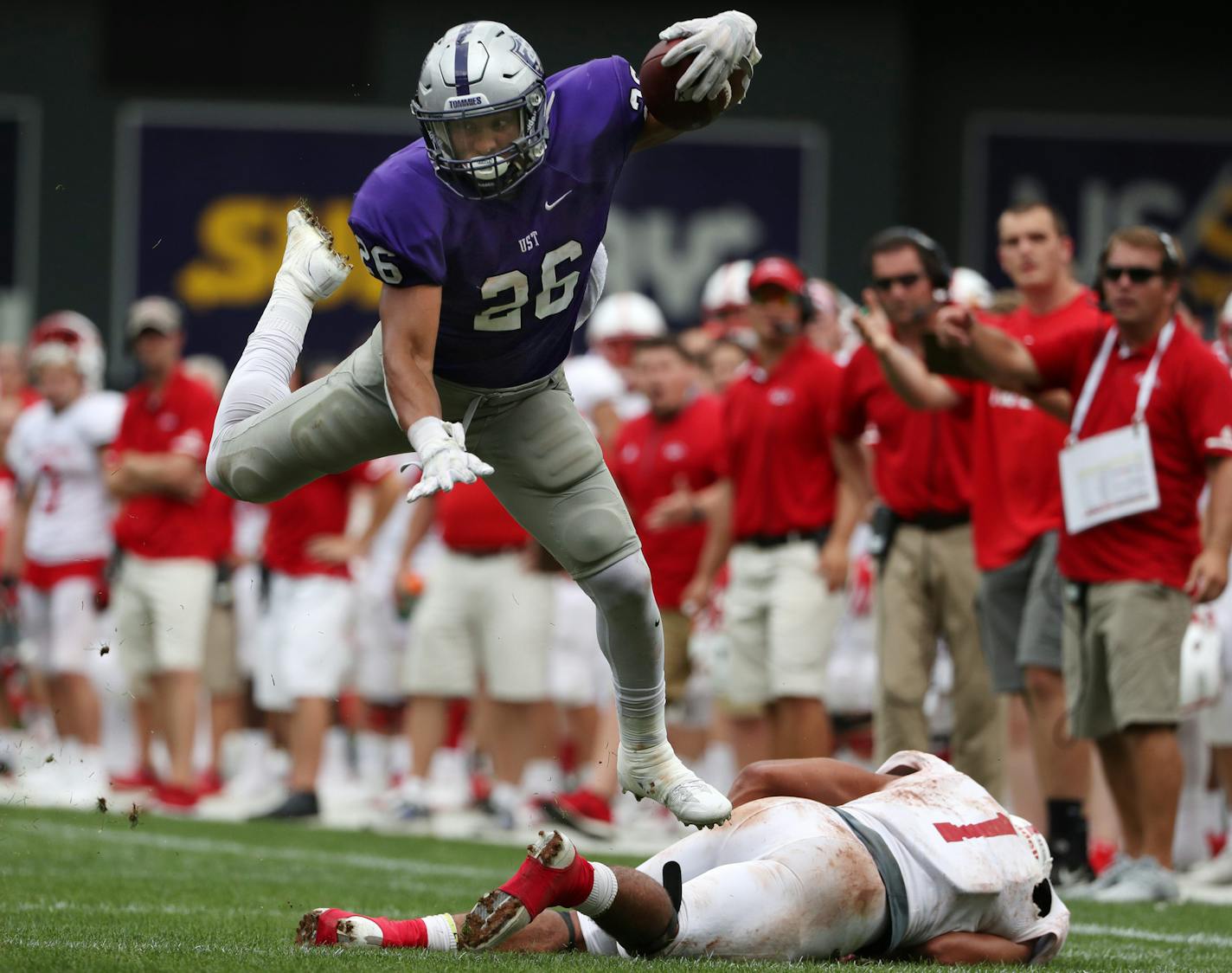 University of St. Thomas running back Josh Parks (26) leapt over St. John's University defensive back Max Jackson (1) as he ran the ball in the second half. ] ANTHONY SOUFFLE &#xef; anthony.souffle@startribune.com Game action from an NCAA football game between the University of St. Thomas and St. John's University Saturday, Sept. 23, 2017 at Target Field in Minneapolis.