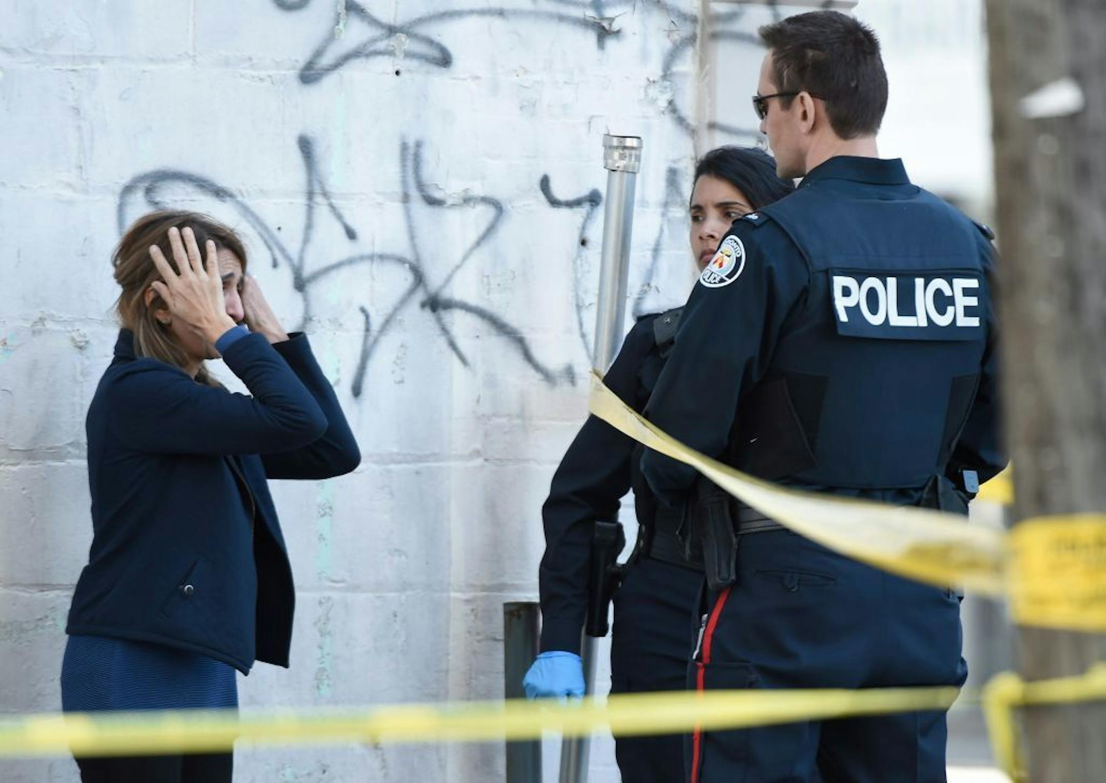 Toronto police officers talk to a woman after a van mounted a sidewalk crashing into a crowd of pedestrians in Toronto on Monday, April 23, 2018. The van apparently jumped a curb Monday in a busy intersection in Toronto and struck the pedestrians and fled the scene before it was found and the driver was taken into custody, Canadian police said.