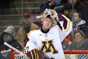 Minnesota Golden Gophers goalie Eric Schierhorn (37) looked up in frustration at the replay board after allowing a tying goal in the second period aga