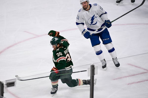 Minnesota Wild right wing Ryan Hartman, left, celebrates after scoring the go-ahead goal while skating past Tampa Bay Lightning left wing Boris Katcho