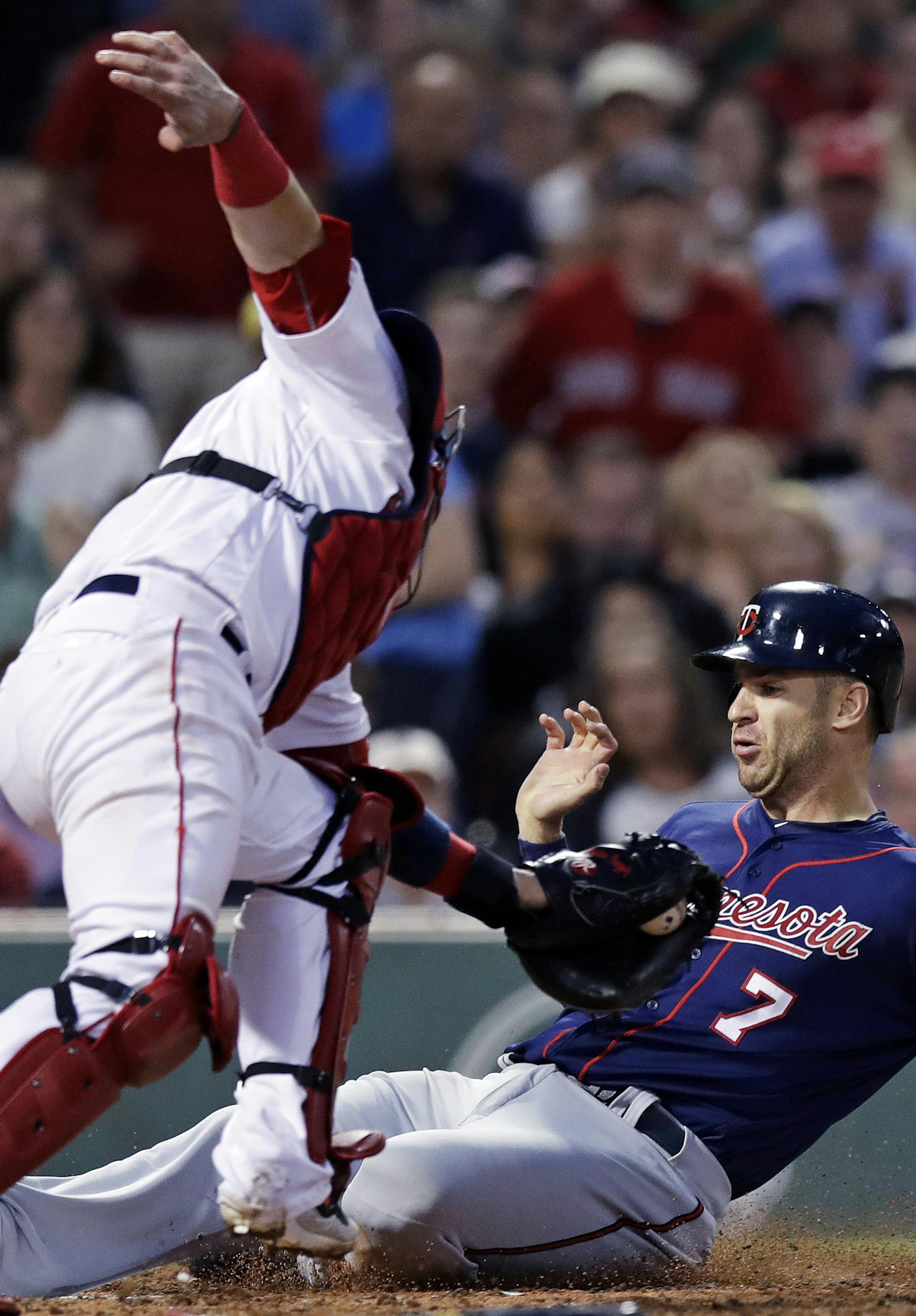 Minnesota Twins' Joe Mauer, right, beats the tag from Boston Red Sox catcher Christian Vazquez to score on a double by Jorge Polanco during the fourth inning of a baseball game at Fenway Park in Boston, Thursday, June 29, 2017. (AP Photo/Charles Krupa)