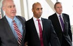 Former Minneapolis police officer Mohamed Noor, center, leaves the Hennepin County Government Center after the first day of jury selection with his at