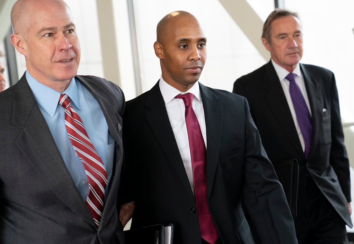 Former Minneapolis police officer Mohamed Noor, center, leaves the Hennepin County Government Center after the first day of jury selection with his attorney's Thomas Plunkett, left, and Peter Wold, right, on Monday.