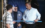 Uponor North America's Bryan Baxter (left), a process engineer; Andy Jensen, barrier line operator; and President Bill Gray inspect tubing manufacture
