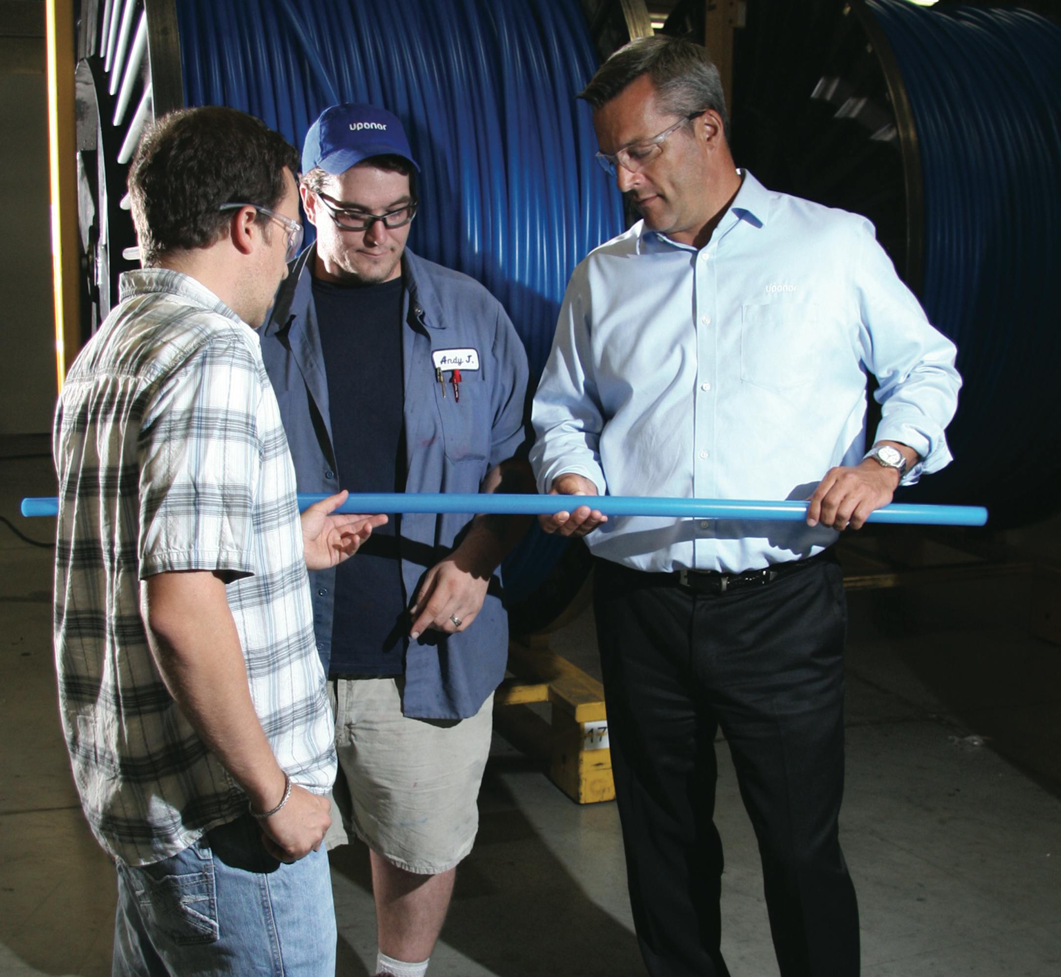 Uponor North America's Bryan Baxter (left), a process engineer; Andy Jensen, barrier line operator; and President Bill Gray inspect tubing manufactured in Apple Valley.