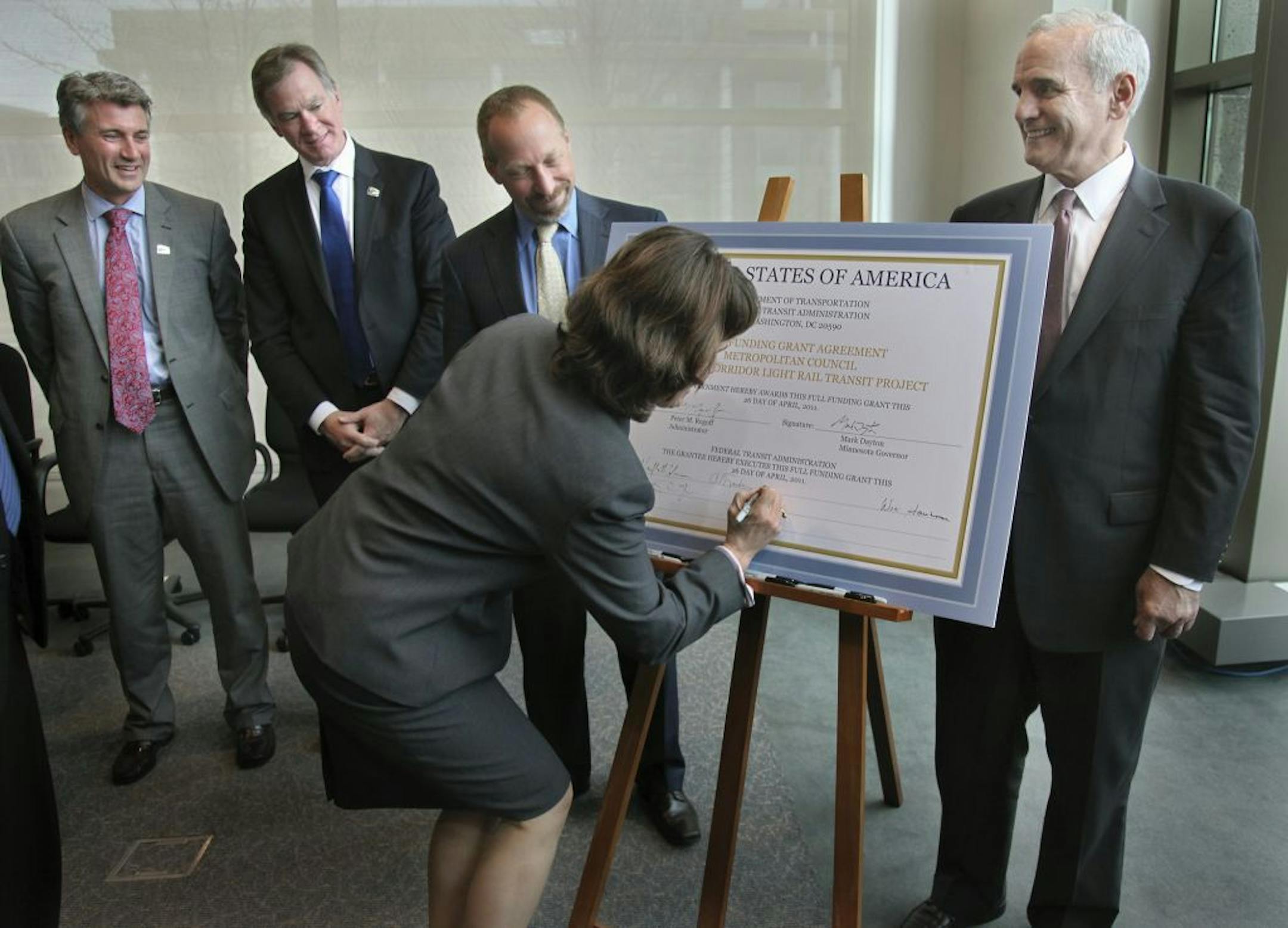 U.S. Rep. Betty McCollum signed a placard for the federal portion of the bill for the Central Corridor line. From left behind her: Mayors R.T. Rybak and Chris Coleman, and Peter Rogoff of the FTA. At right is Gov. Mark Dayton.